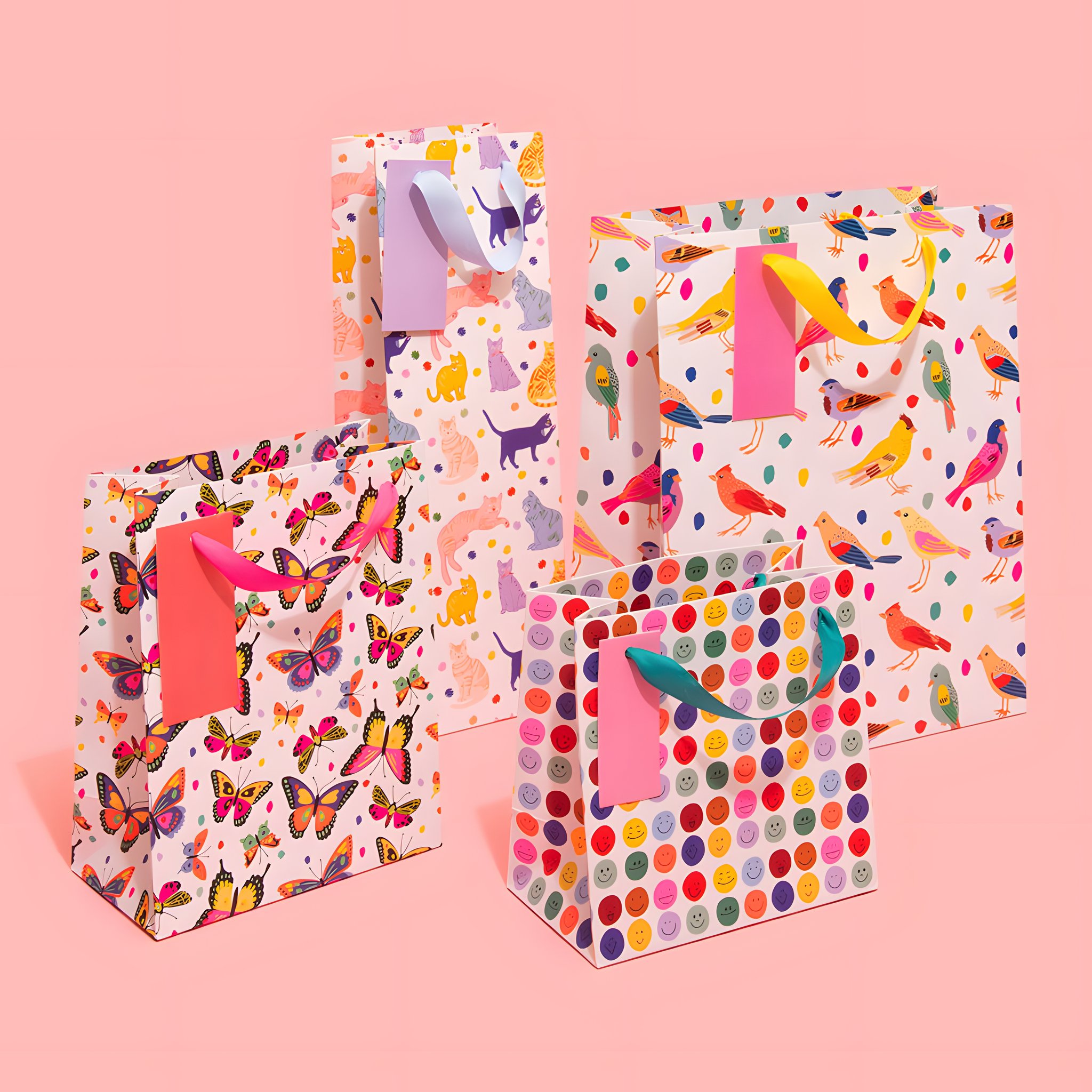 Busta regalo piccola con smiley colorati insieme ad altre buste regalo Ohh Deer su sfondo colorato