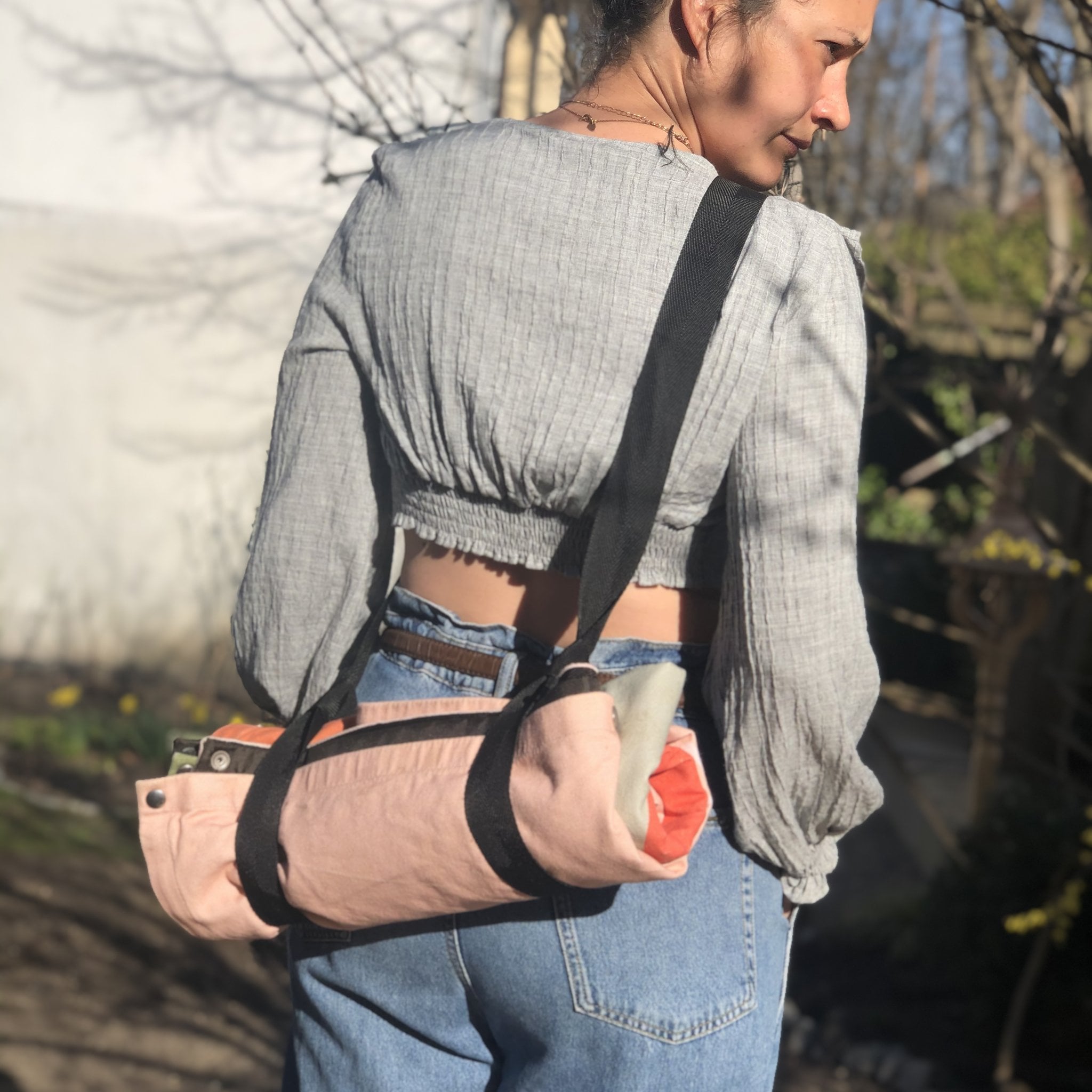 Donna che porta la coperta arrotolata con la tracolla