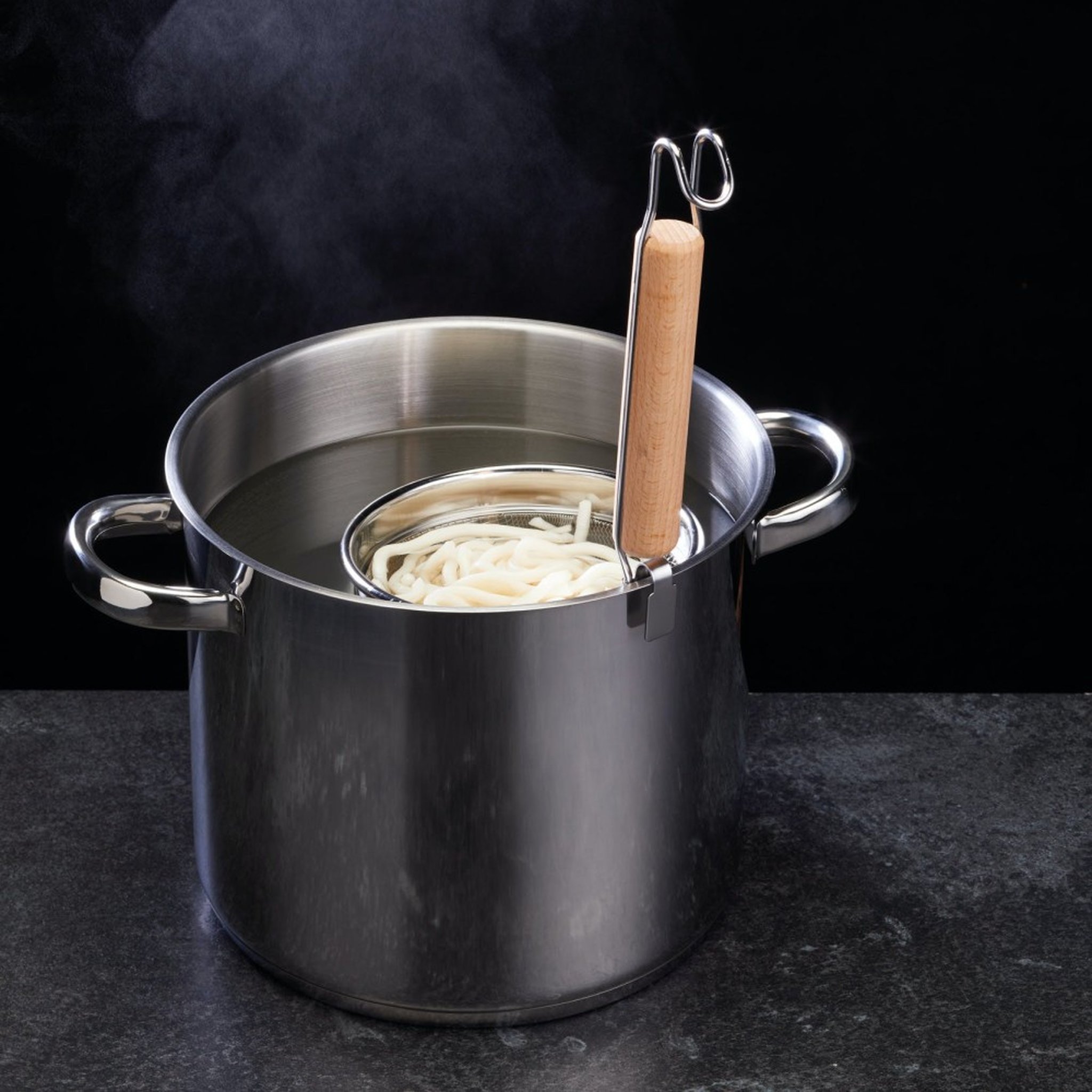 Scolapasta in pentola fumante con noodle udon