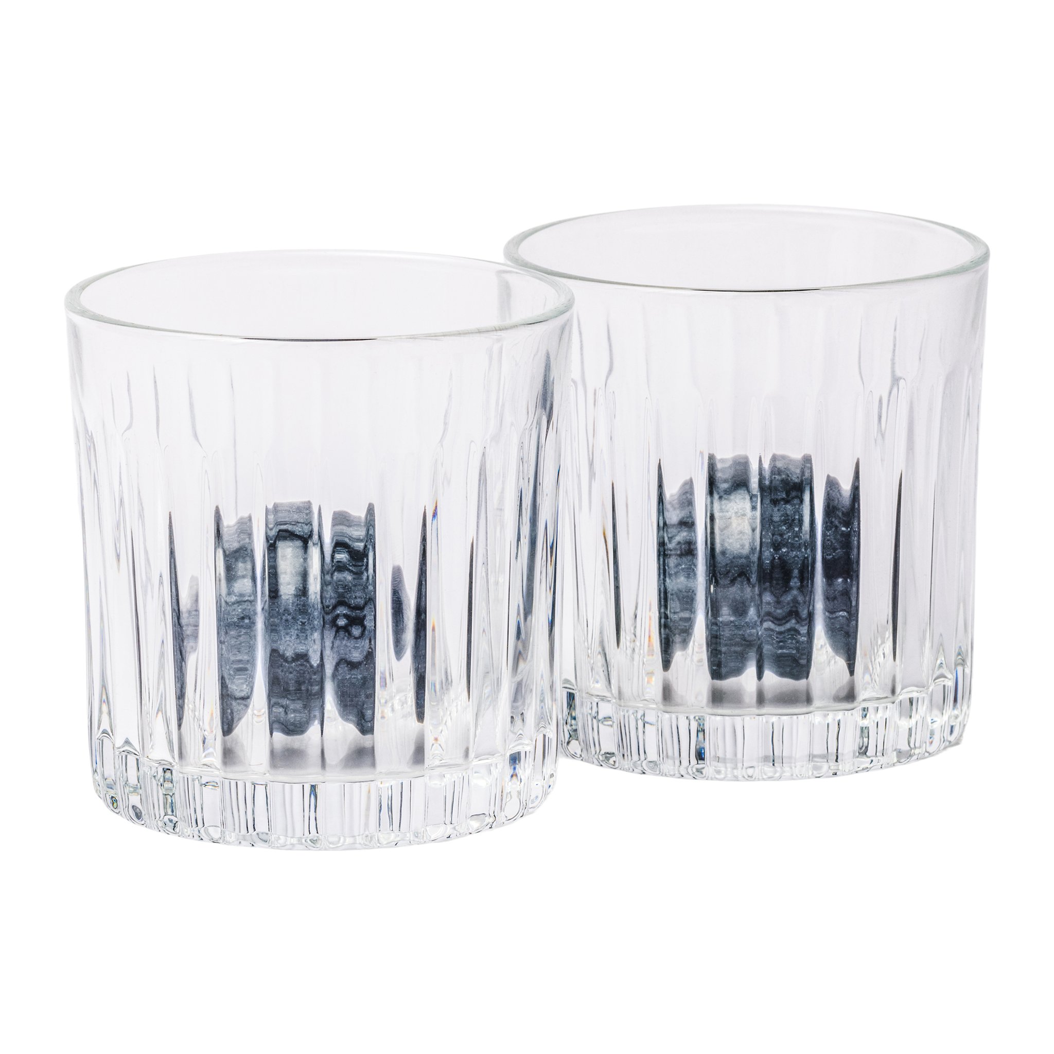 Zwei leere, geriffelte Whisky-Gläser des Whiskey Lover's Set, durch das Glas schimmern dunkle Granitkugeln