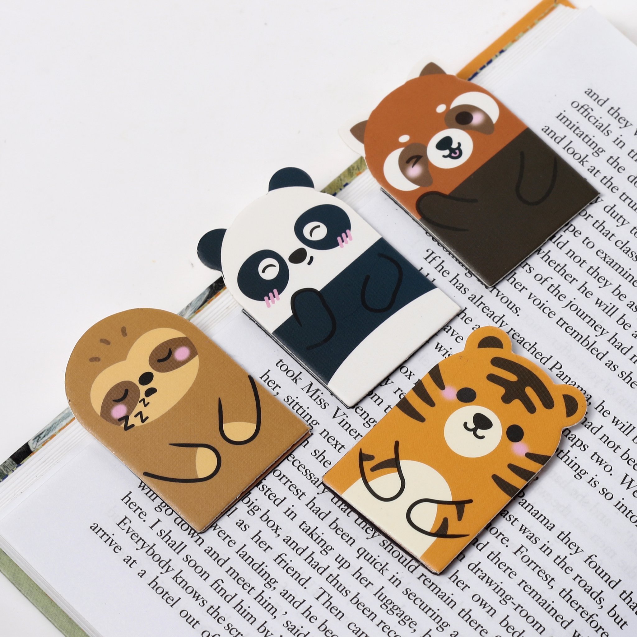 Quatre marque-pages magnetiques Adoramals sur un livre ouvert