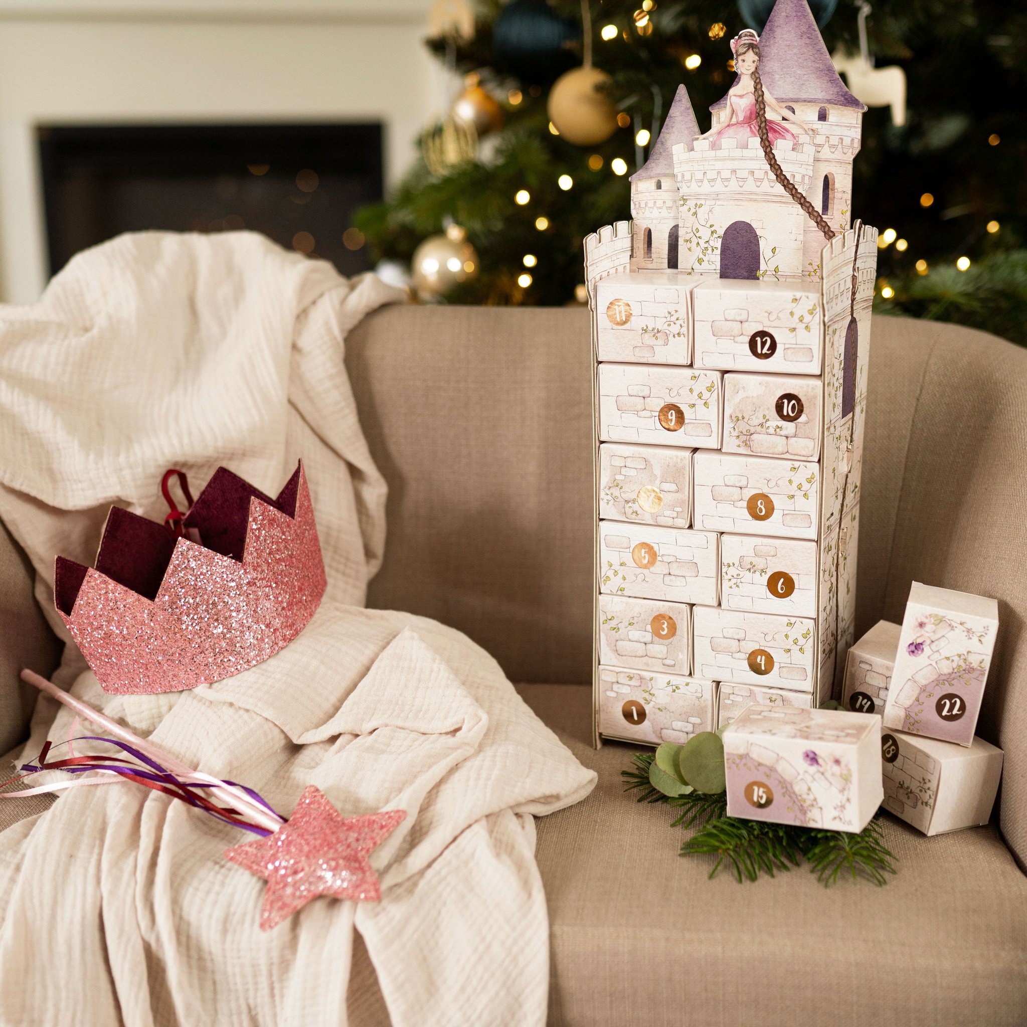 Fertiger Rapunzelturm aus 24 Schachteln auf dem Sofa vor dem Weihnachtsbaum, mit Krone und Stern