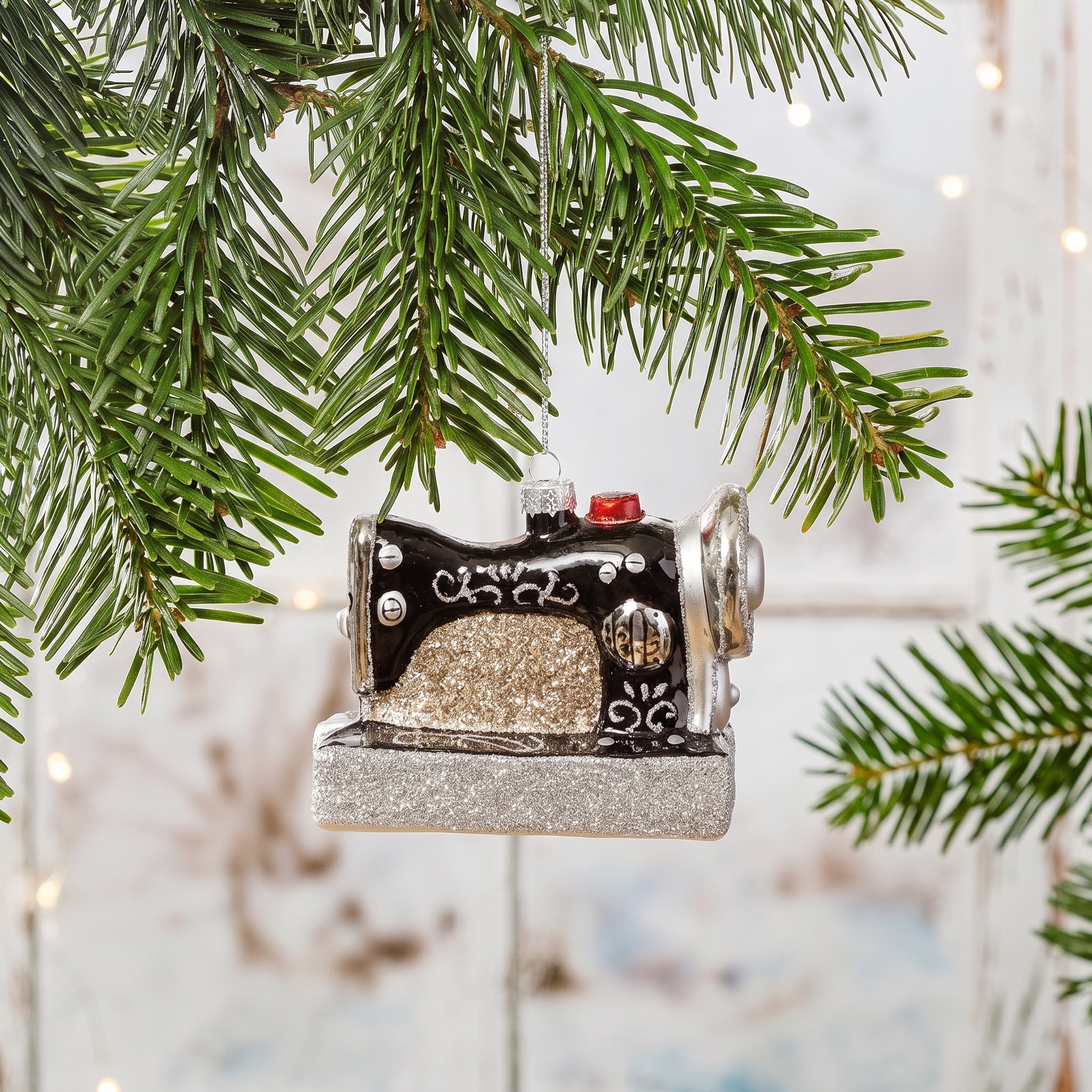 Retro Sewing Machine Shaped Bauble by Sass & Belle on a fir branch against pale wood