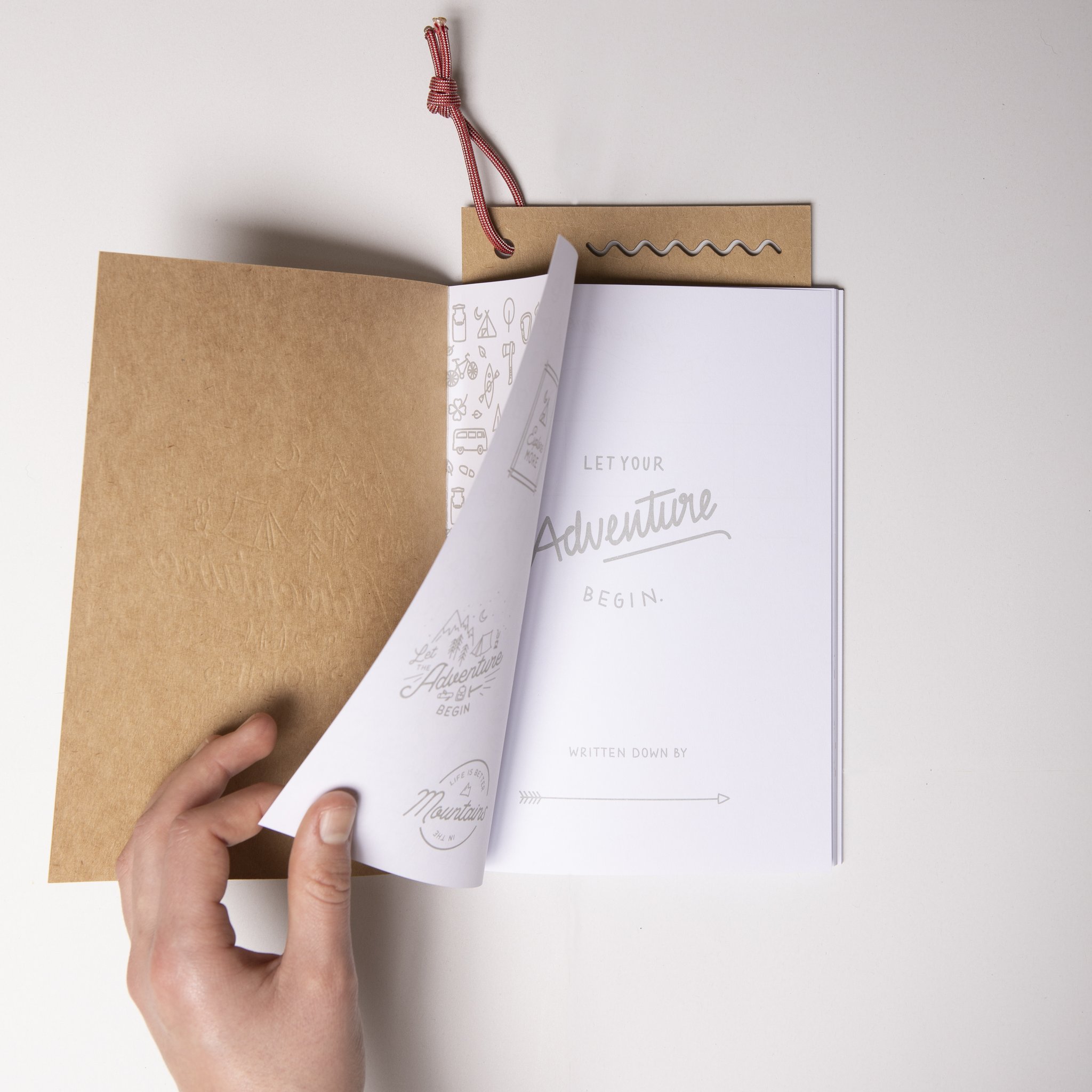 Reisetagebuch mit aufgeschlagenem Kraftpapier-Umschlag und rotem Leseband