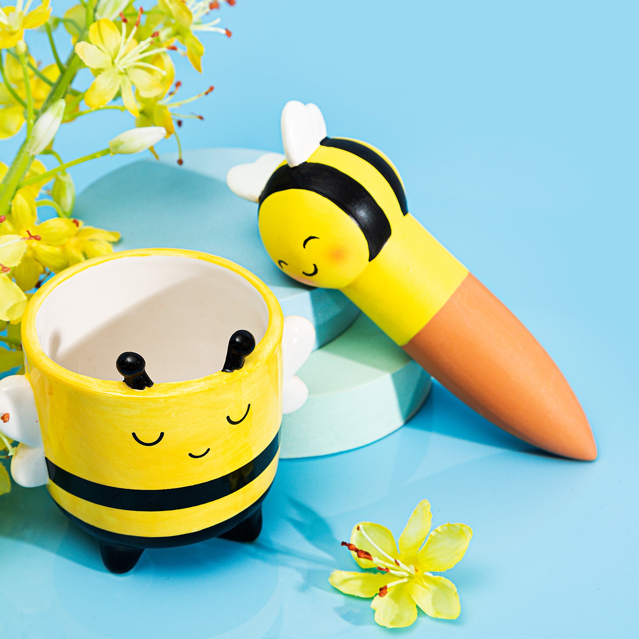 Bienen-Blumentopf mit gelben Blüten auf hellblauem Hintergrund