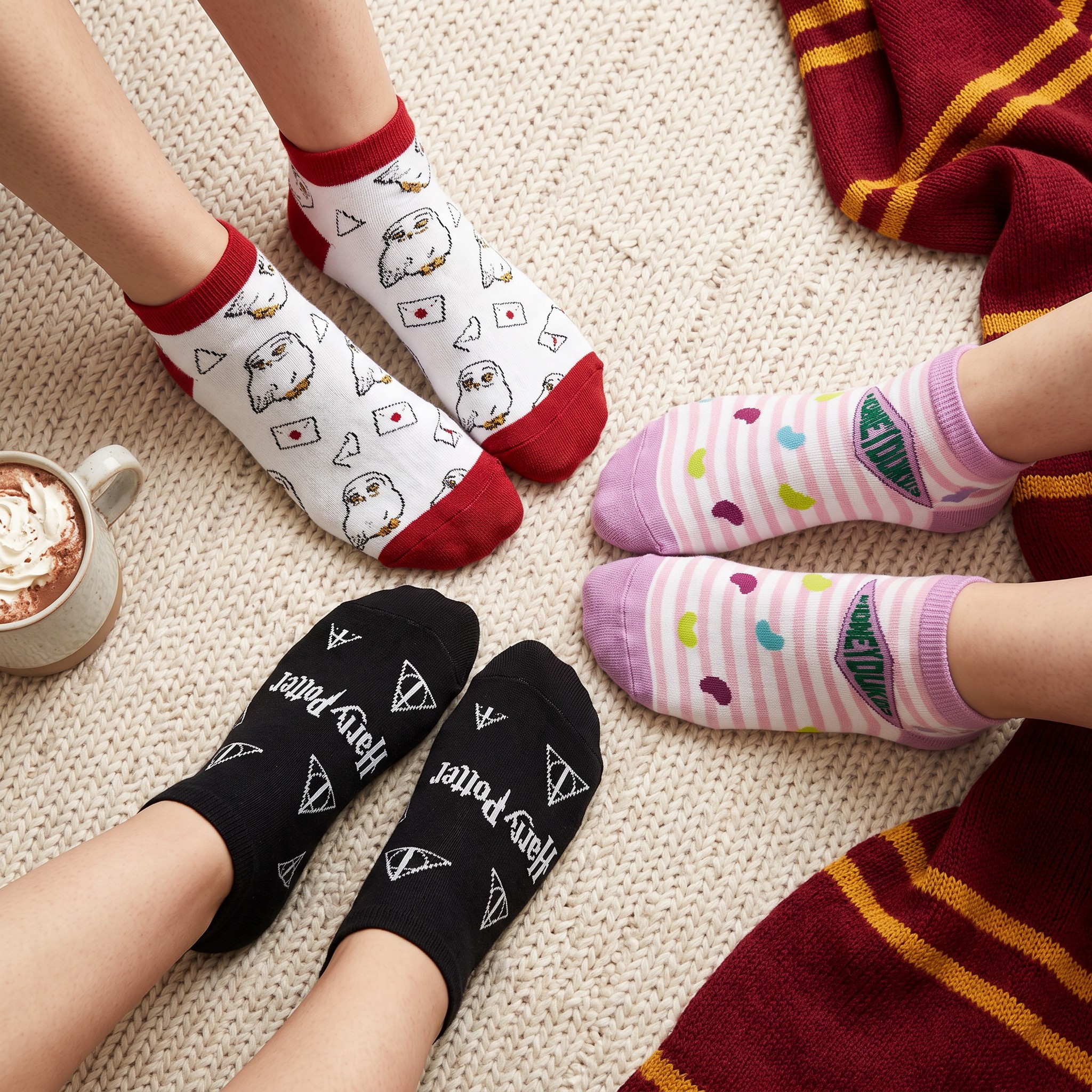 Trois paires de socquettes Harry Potter avec Hedwige, Honeydukes et les Reliques de la Mort, portées sur un tapis tricoté