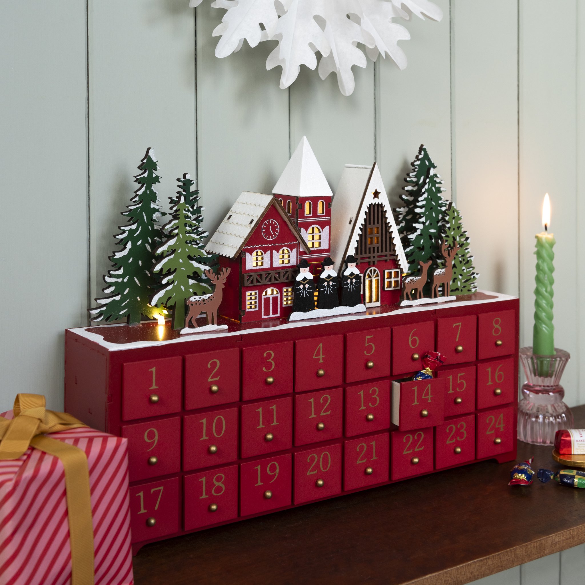 Weihnachtssinger Adventskalender mit geöffneter Schublade, Kerze und Geschenk