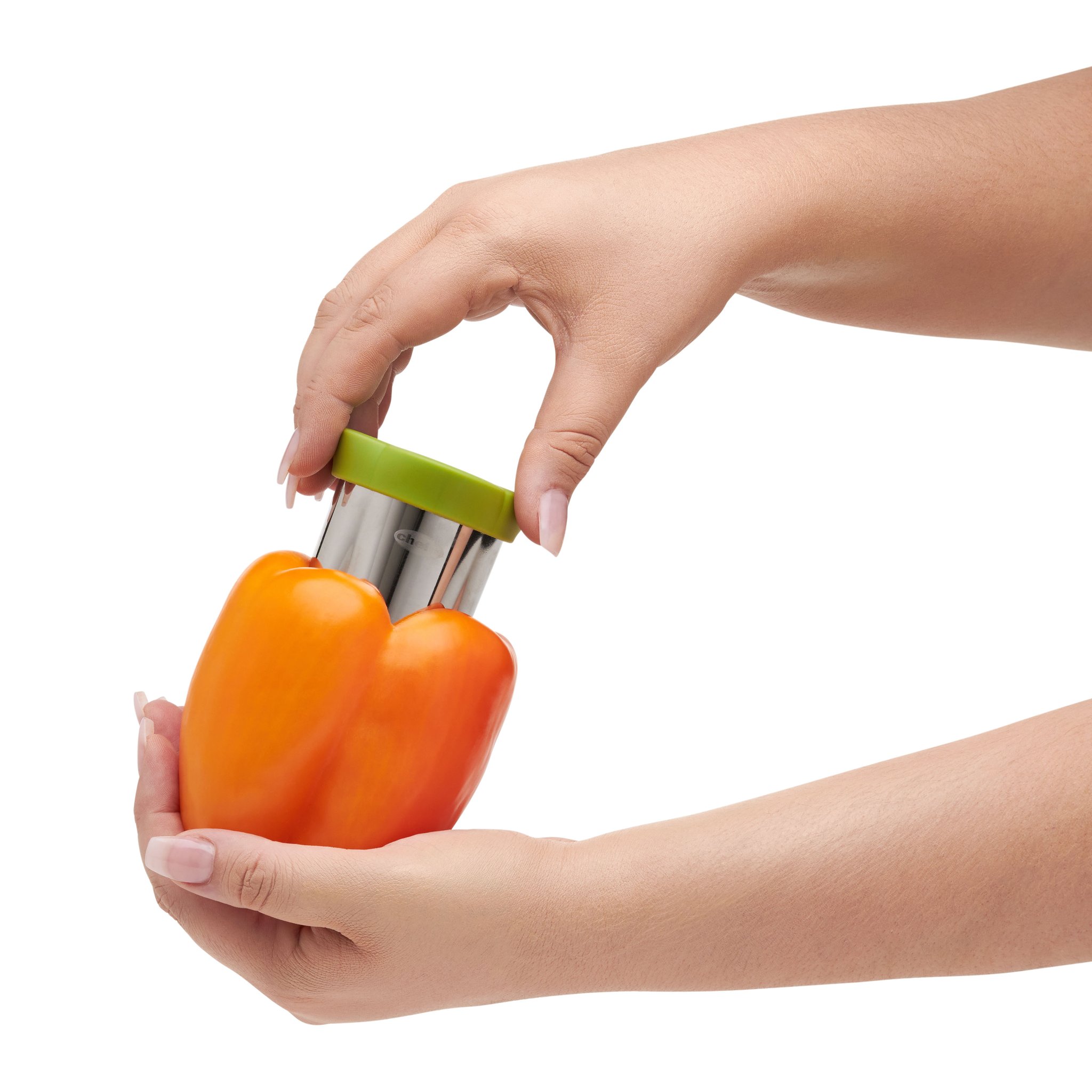 Hände drücken den Paprika-Entkerner von oben in eine orange Paprika