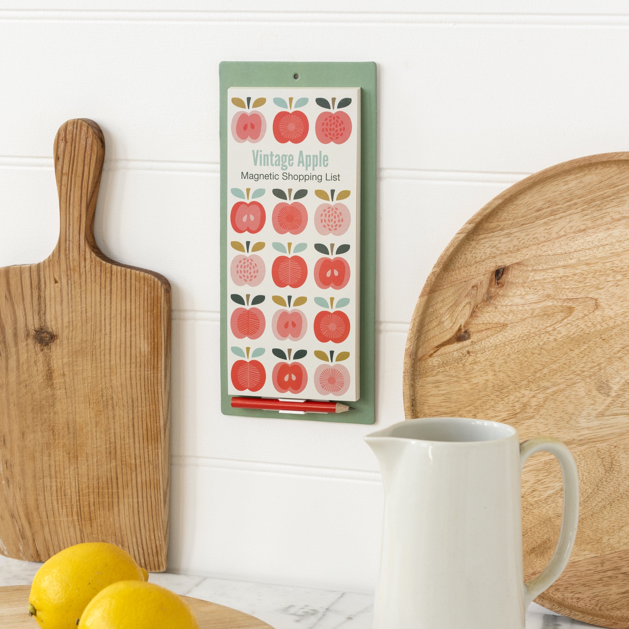 Vintage Apple Magnet-Einkaufsliste an der Küchenwand neben Schneidebrett und Krug