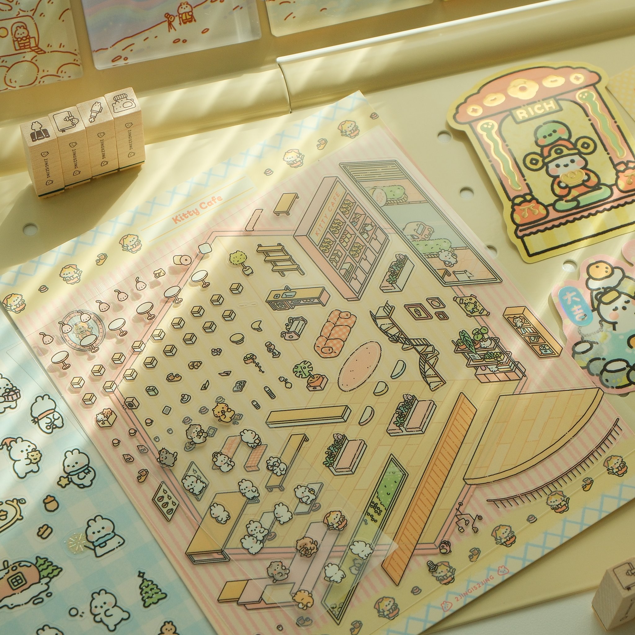 Close-up of the sticker sheet with cups, pastries, furniture and small cats