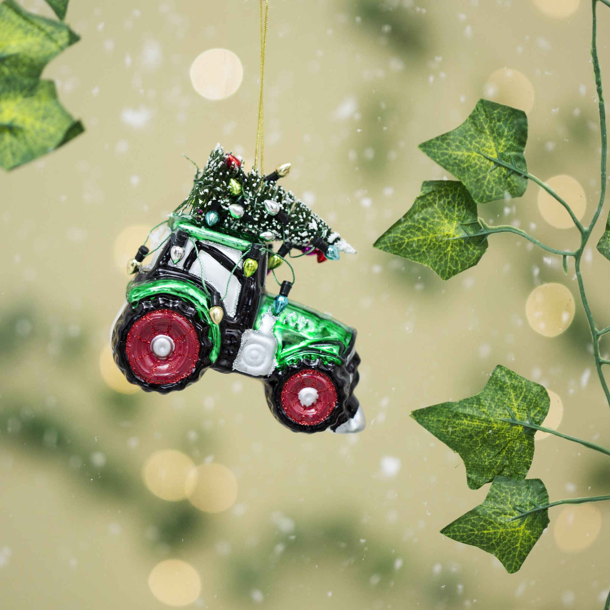 Tractor Christmas tree decoration hanging among ivy leaves