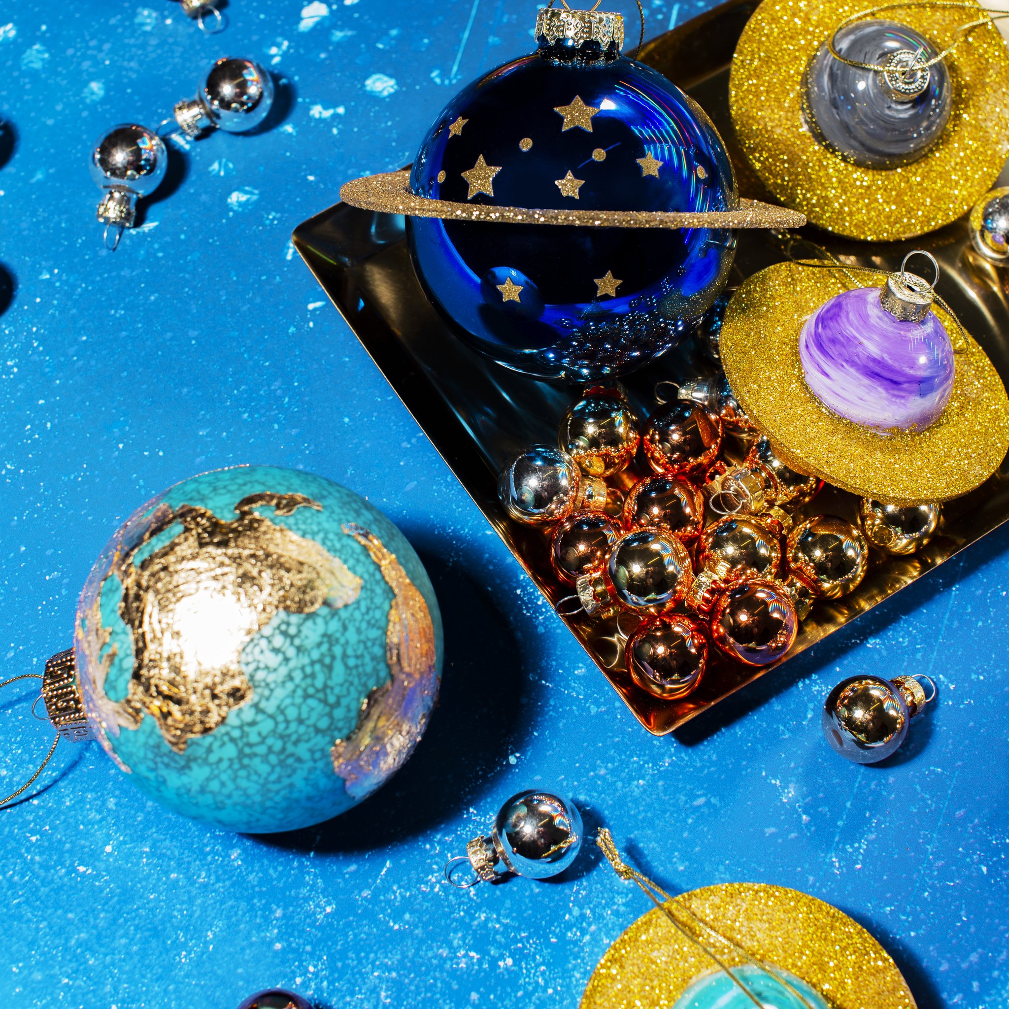 Glass globe bauble among planet decorations on a blue starry backdrop