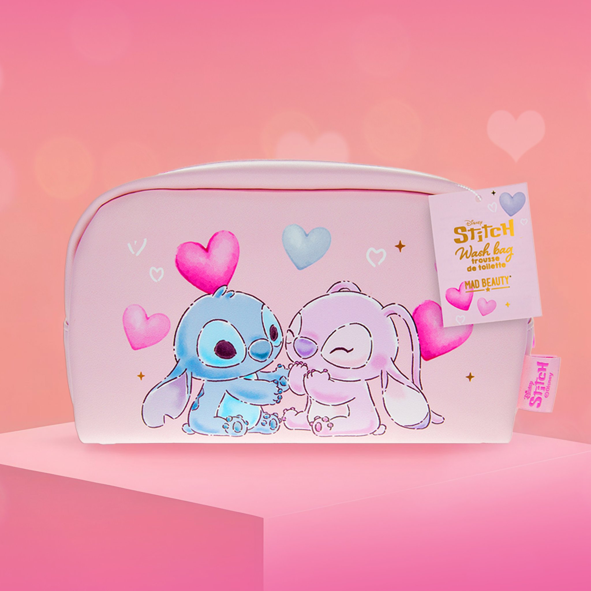 Pochette cosmetica bianca I Heart Stitch con Stitch, Angel e cuori, appoggiata su un podio rosa