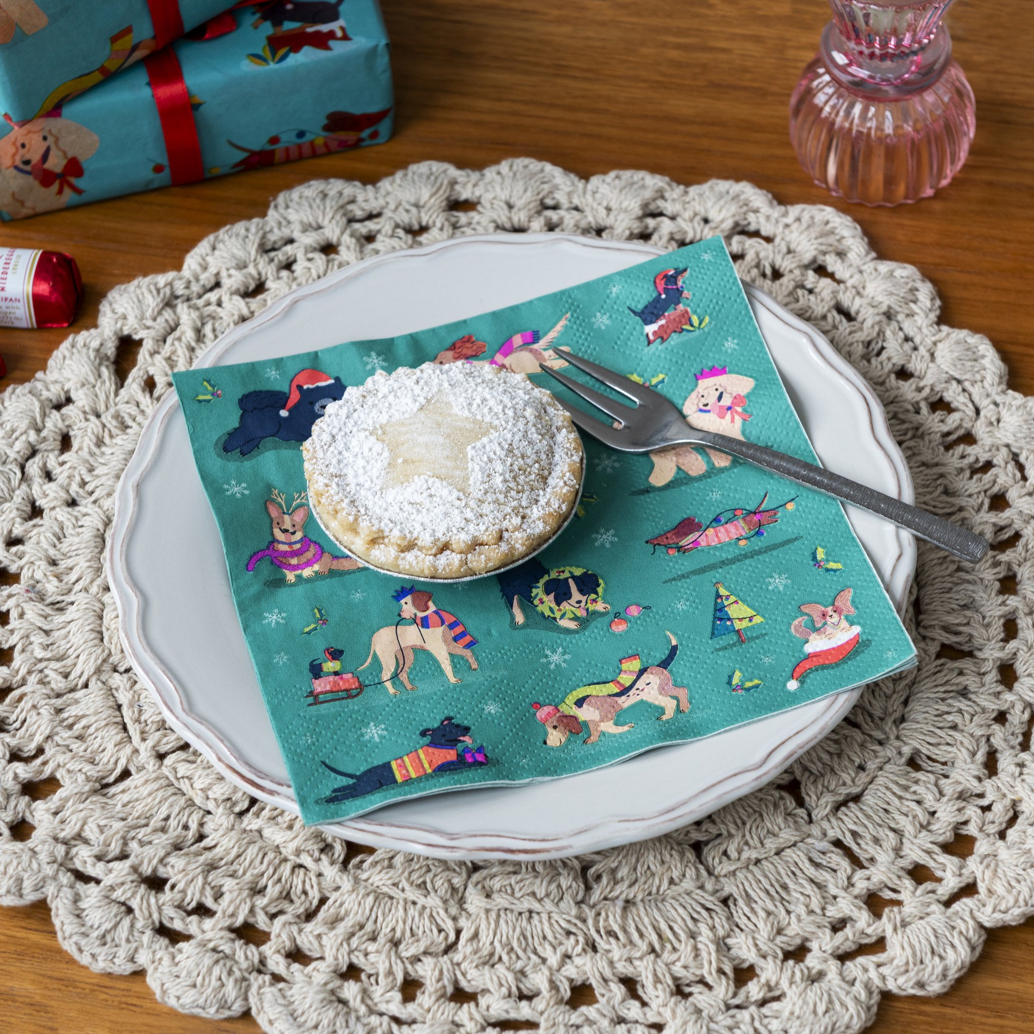 Serviette en papier Festive Friends avec chiens sous une tartelette sur la table de Noël