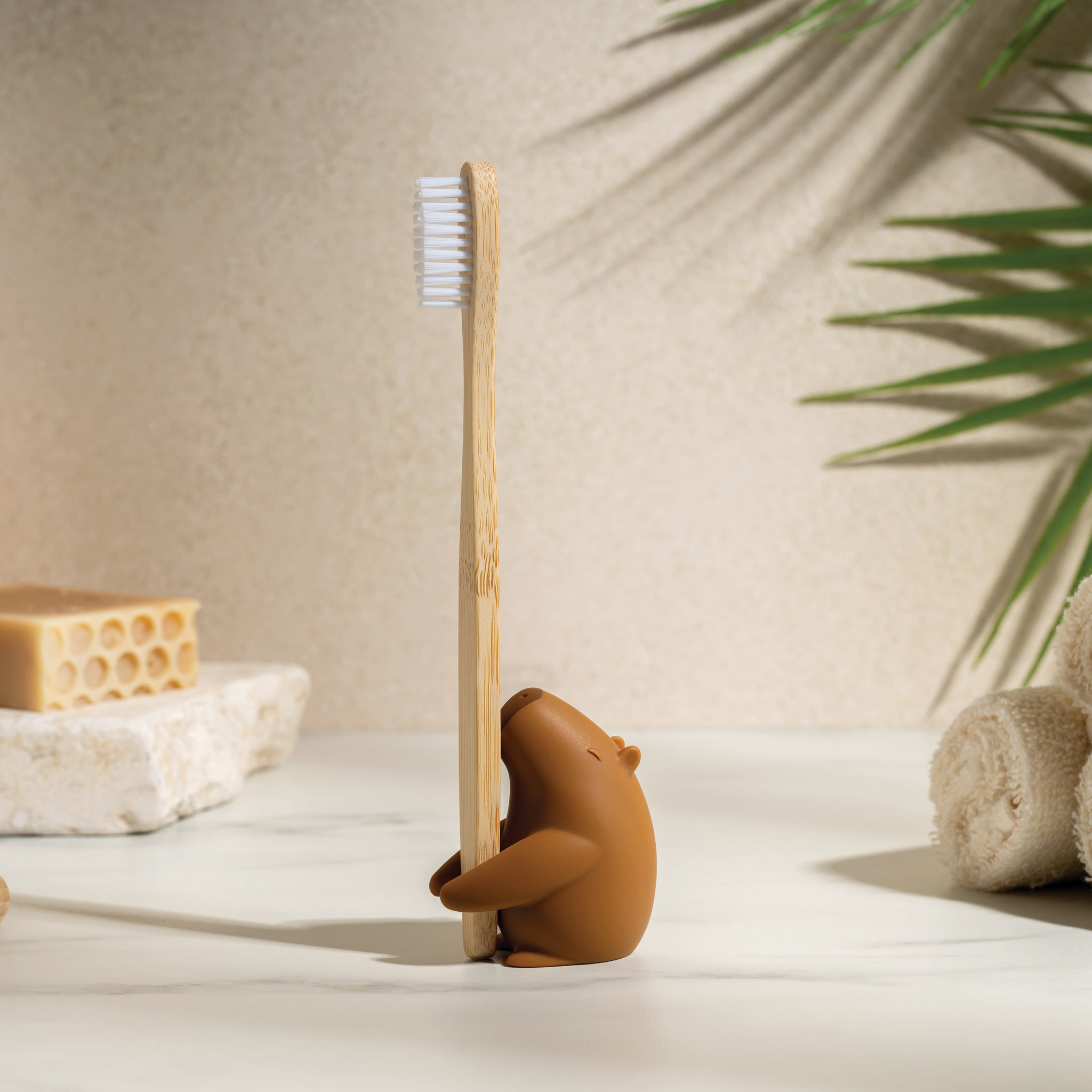 Capybrush am Waschbecken neben Schwamm, Seife und Handtuechern