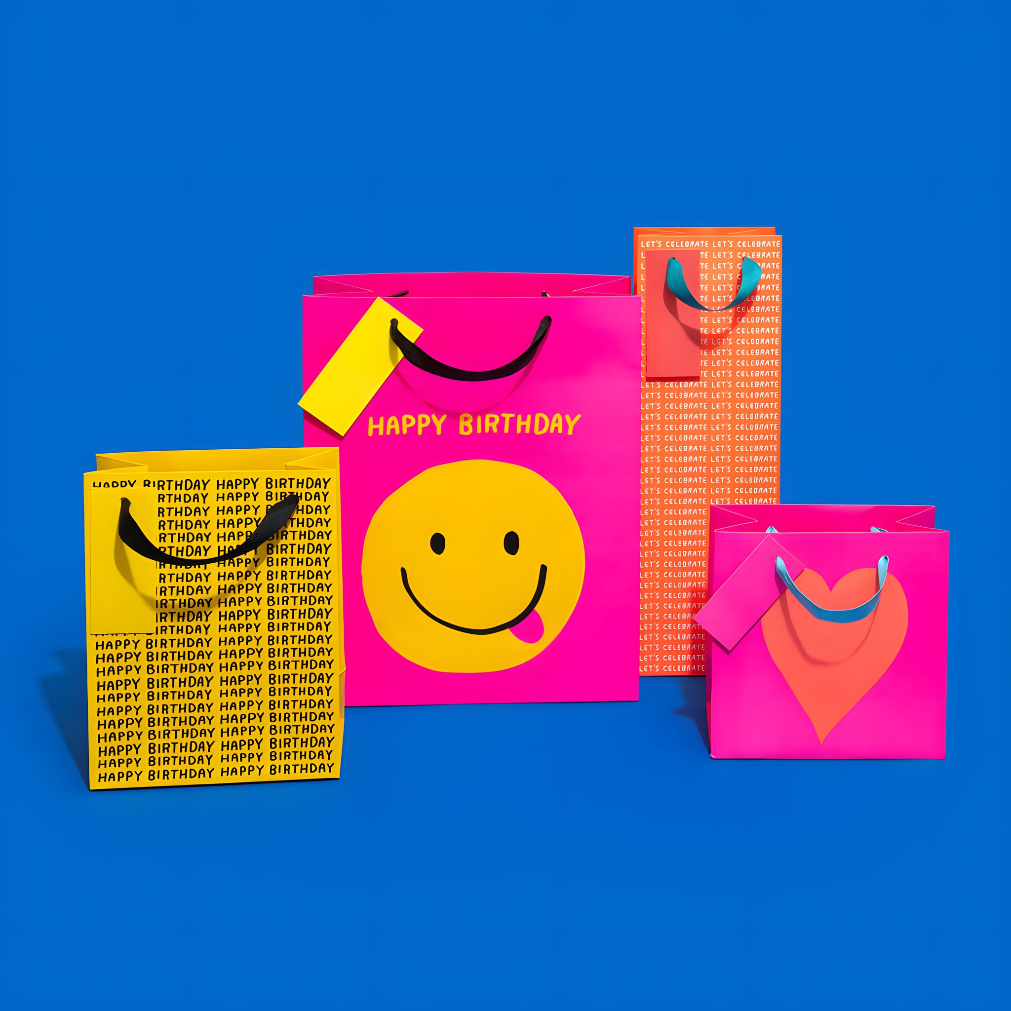 Busta regalo piccola con cuore neon insieme ad altre buste regalo Ohh Deer su sfondo colorato