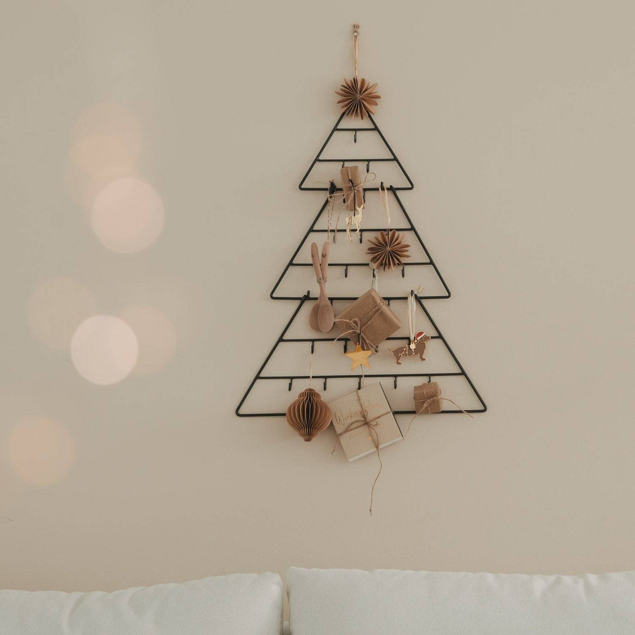 Adventskalender Tanne über einem Sofa im Wohnzimmer mit warmem Lichterglanz