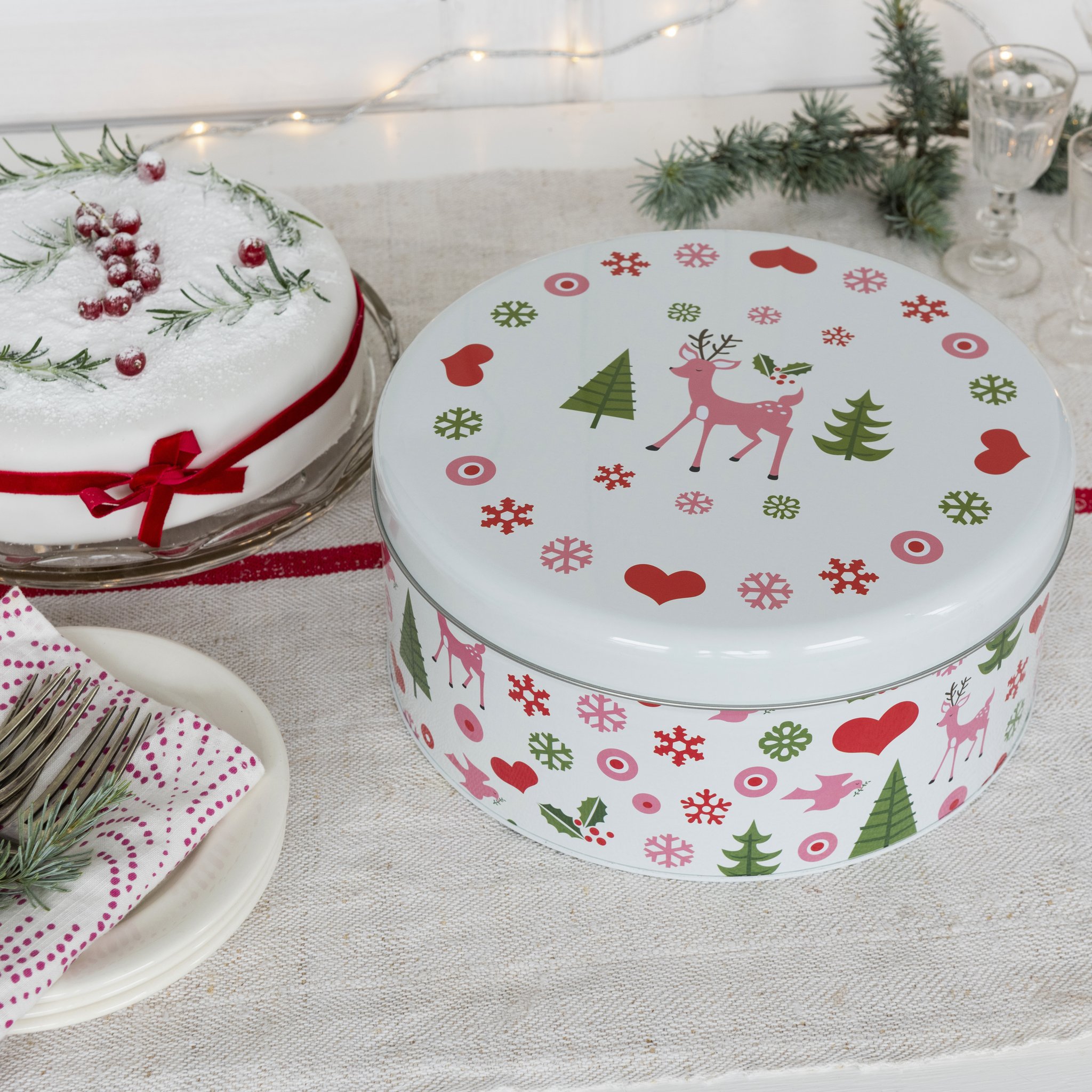 Boîte à biscuits à motif renne et cœurs sur la table de fête à côté d'un gâteau