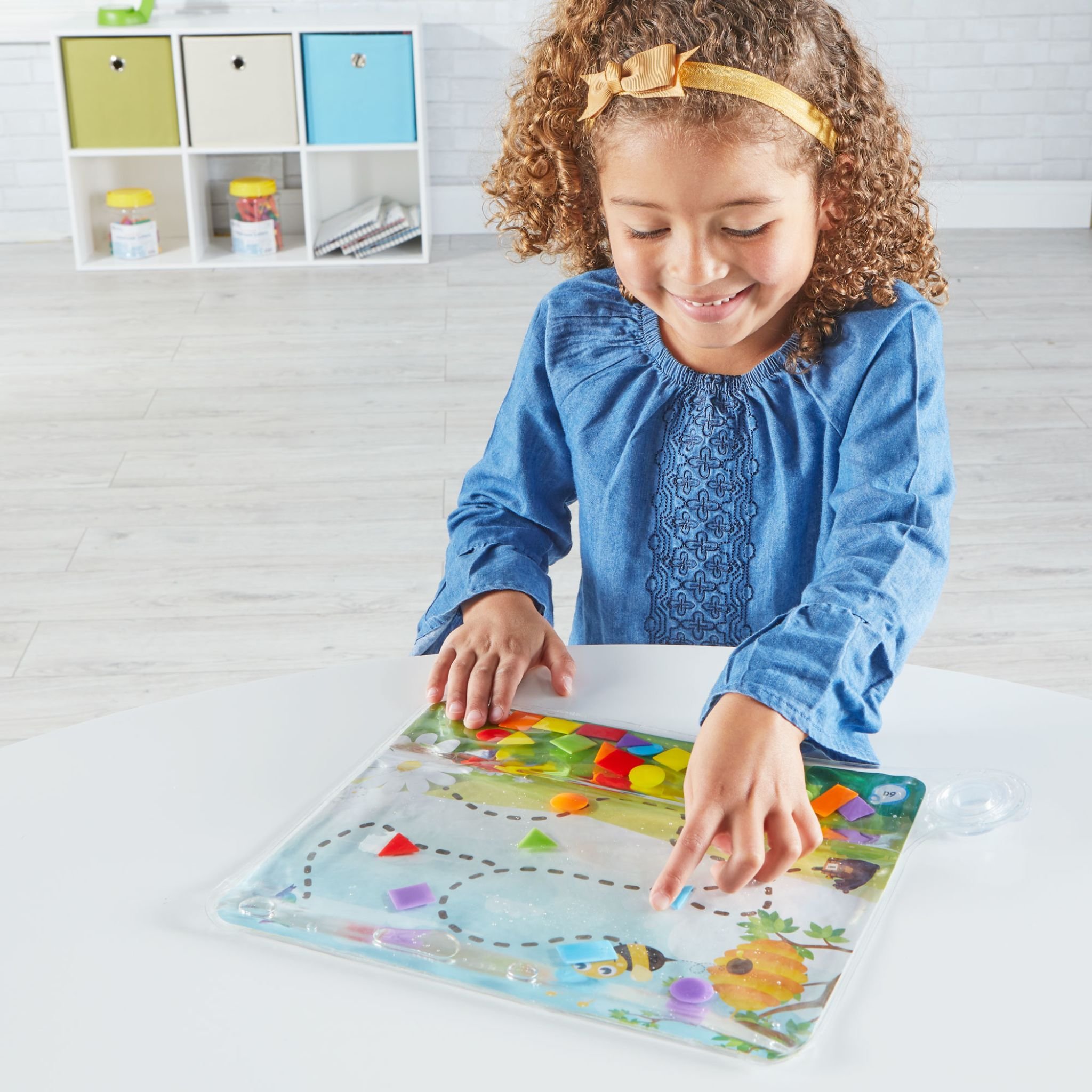 Farben & Formen Sensorik-Pad – Mädchen spielt am Tisch mit dem Pad