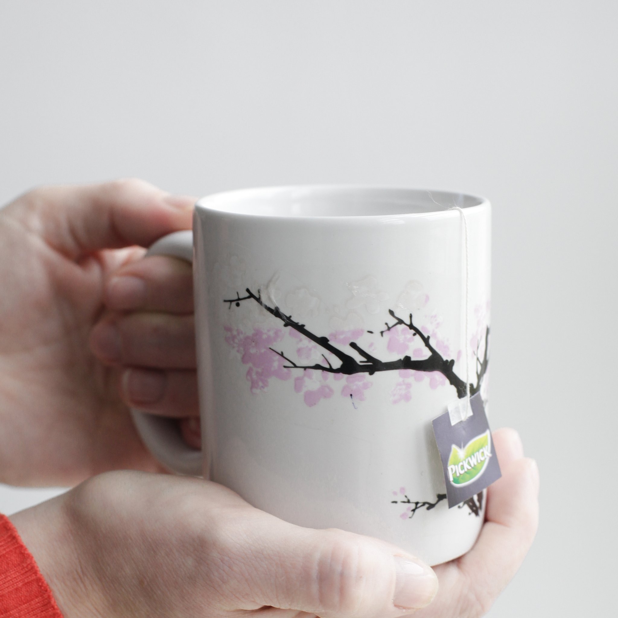 Thermotasse Kirschblüte – Frau hält Tasse mit Tee