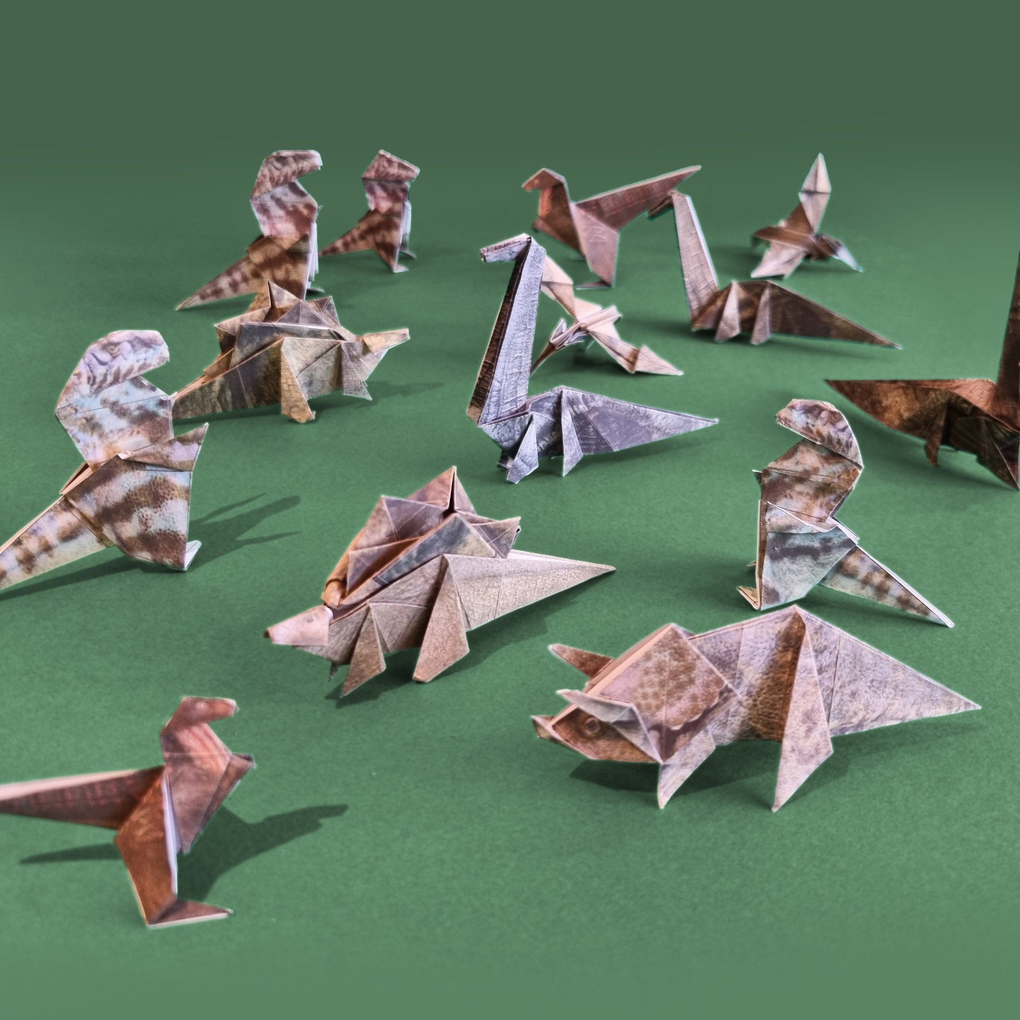 Paper Dinos origami set – group of paper dinosaurs on green