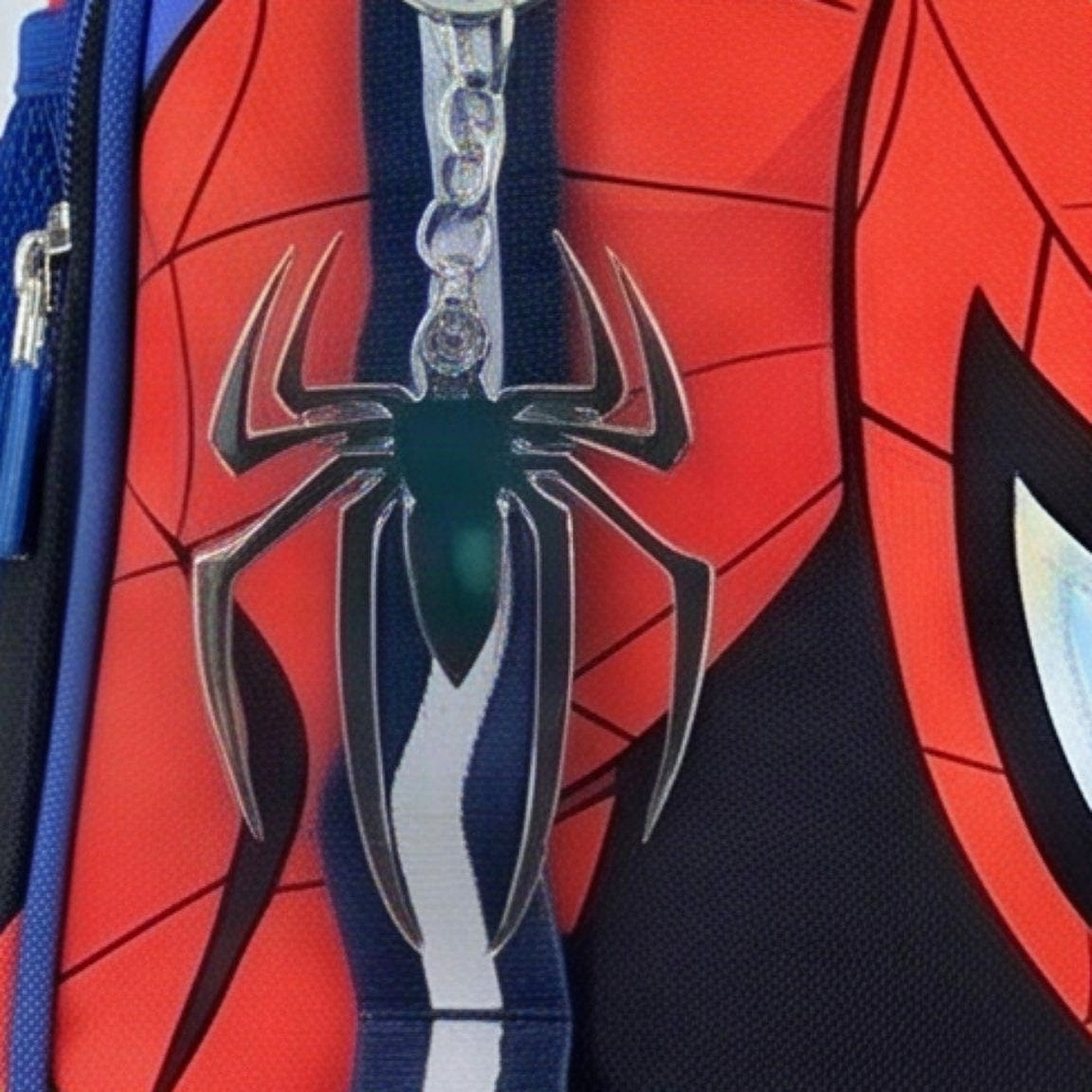 Close-up of the silver spider charm on the front zip