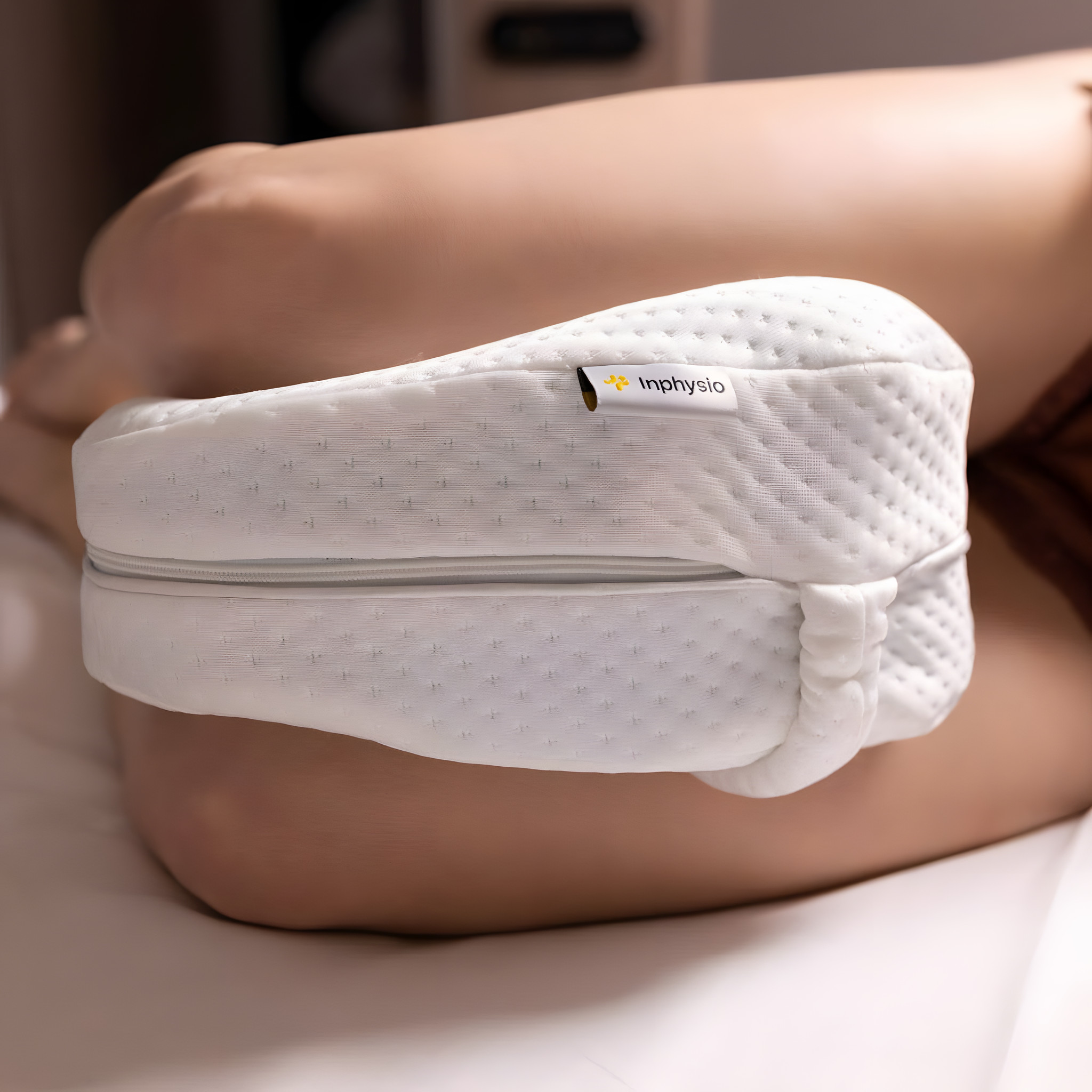 Knie-Kissen in Herzform zwischen den Knien einer Seitenschläferin im Bett