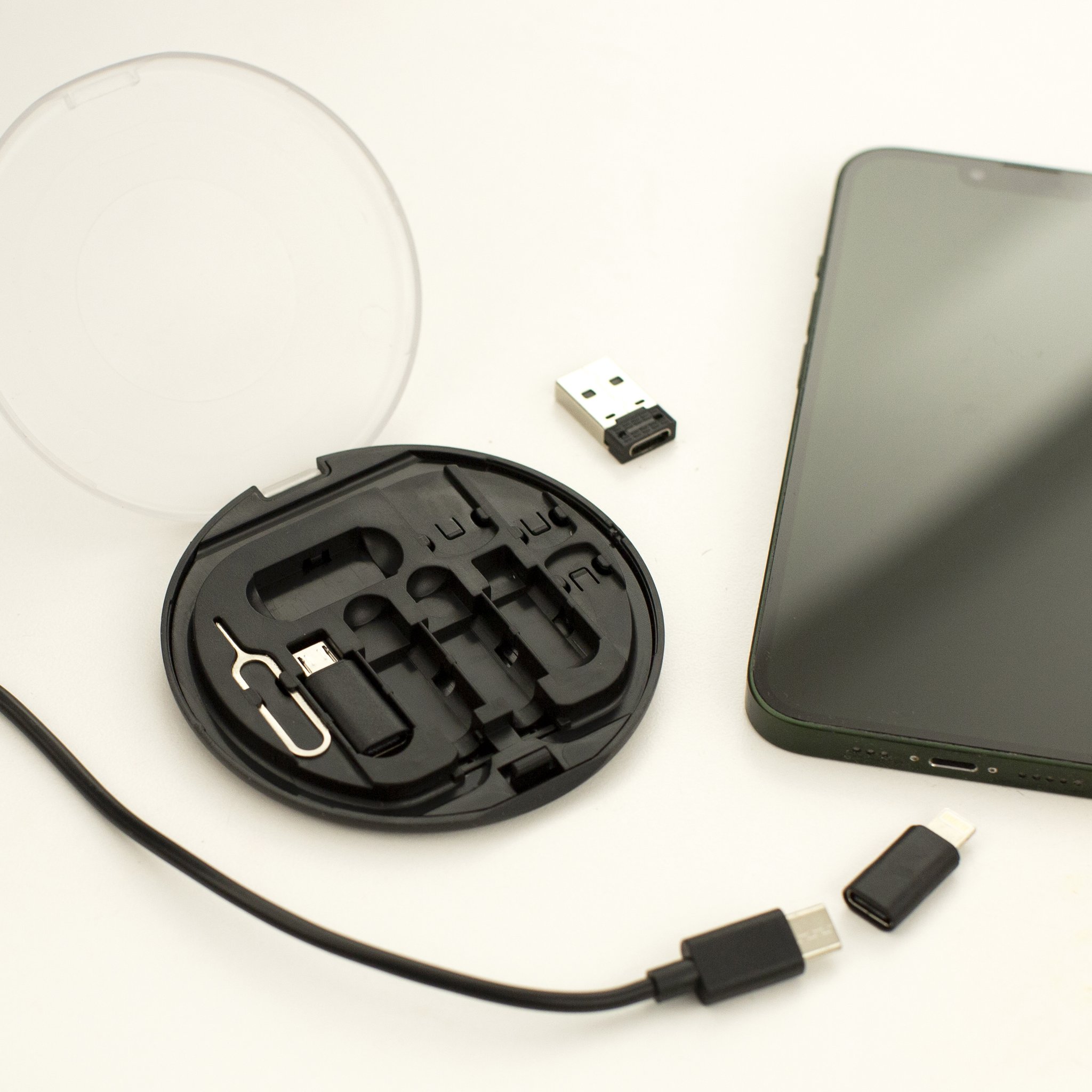Set adattatori Travel Buddy aperto accanto a smartphone con cavo