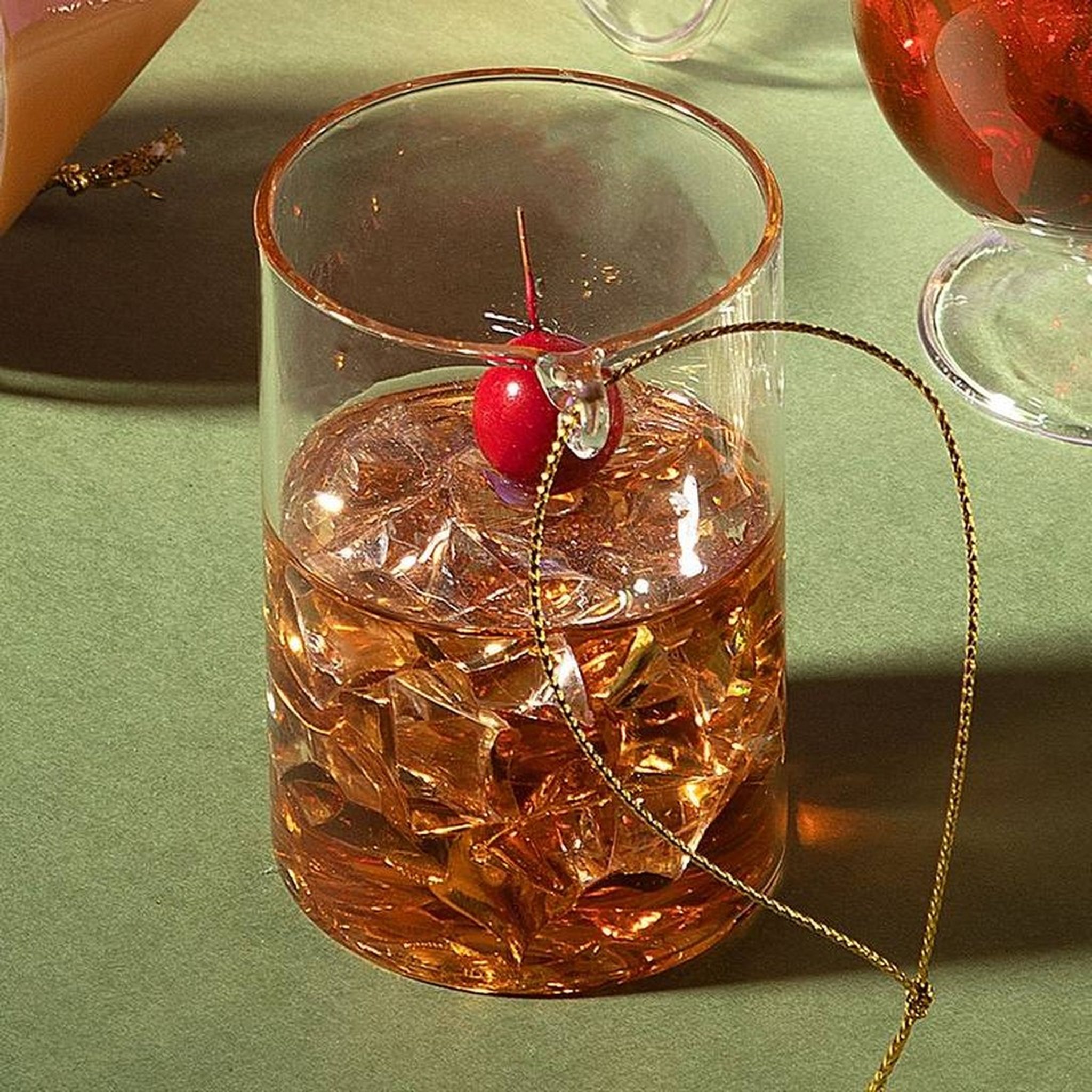 Whiskyglas Weihnachtsbaumschmuck Nahaufnahme mit Kirsche und Goldfaden