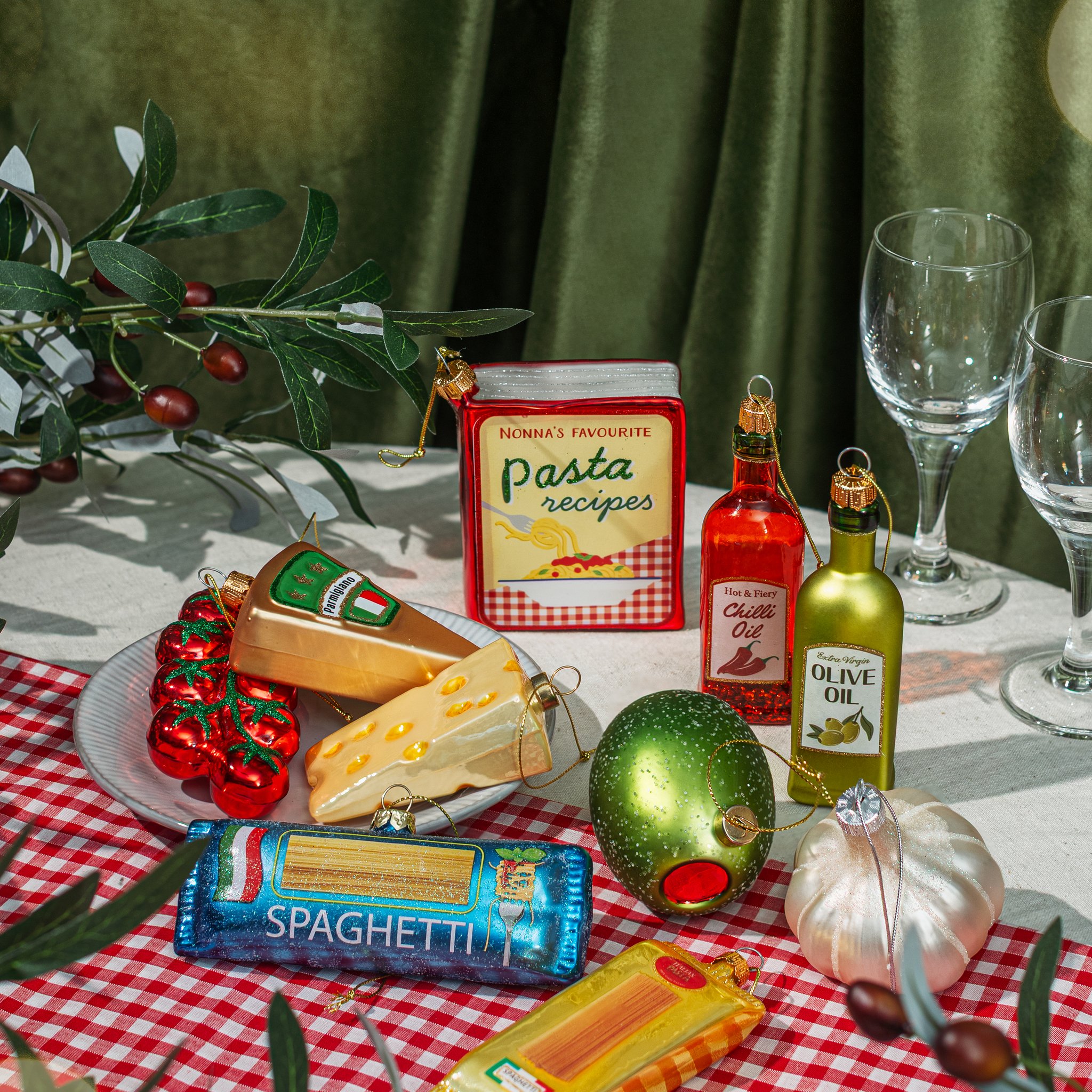 Pacco di spaghetti in vetro su una tavola apparecchiata tra altre decorazioni a tema pasta