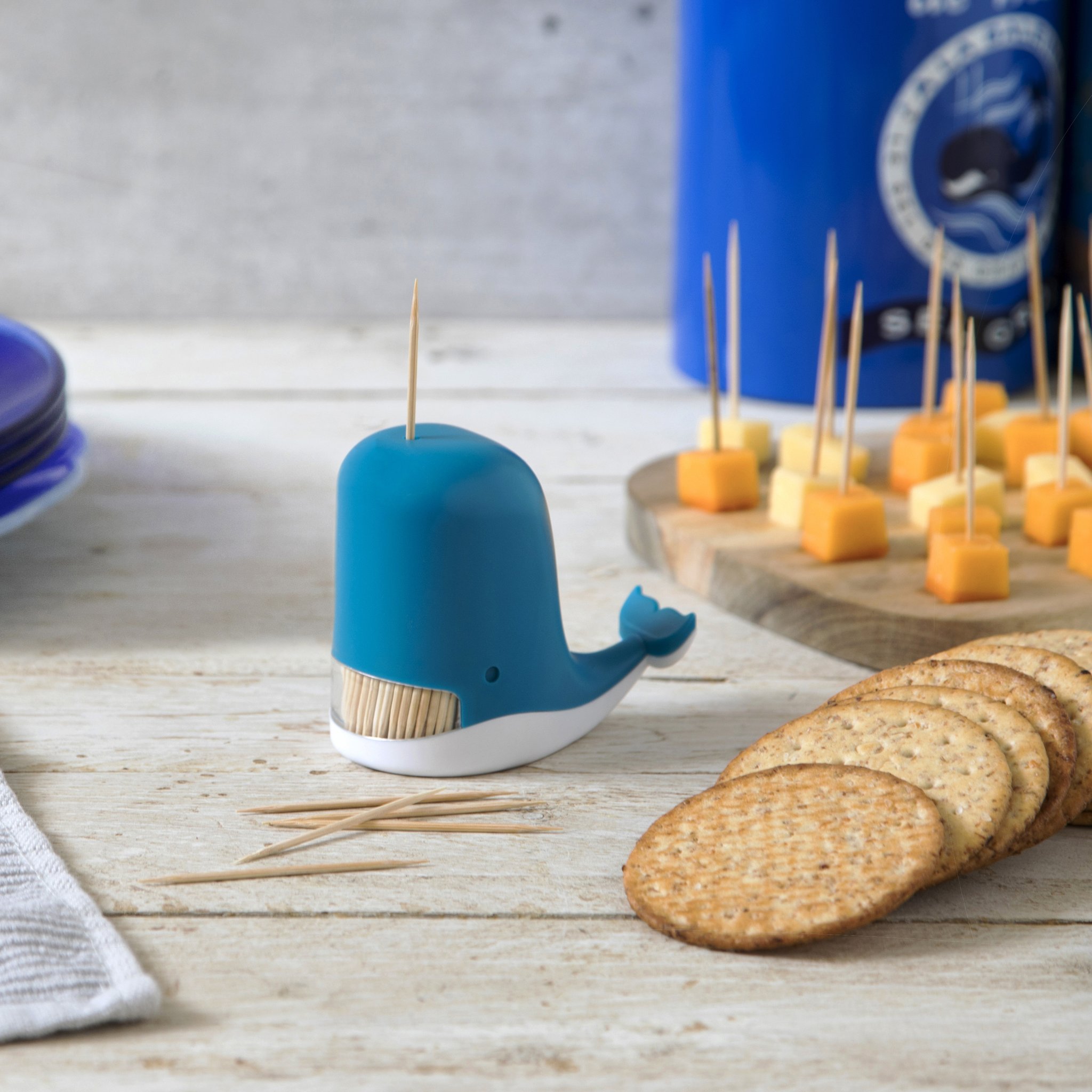 Blauer Wal-Zahnstocherspender neben Crackern und Käsespiessen