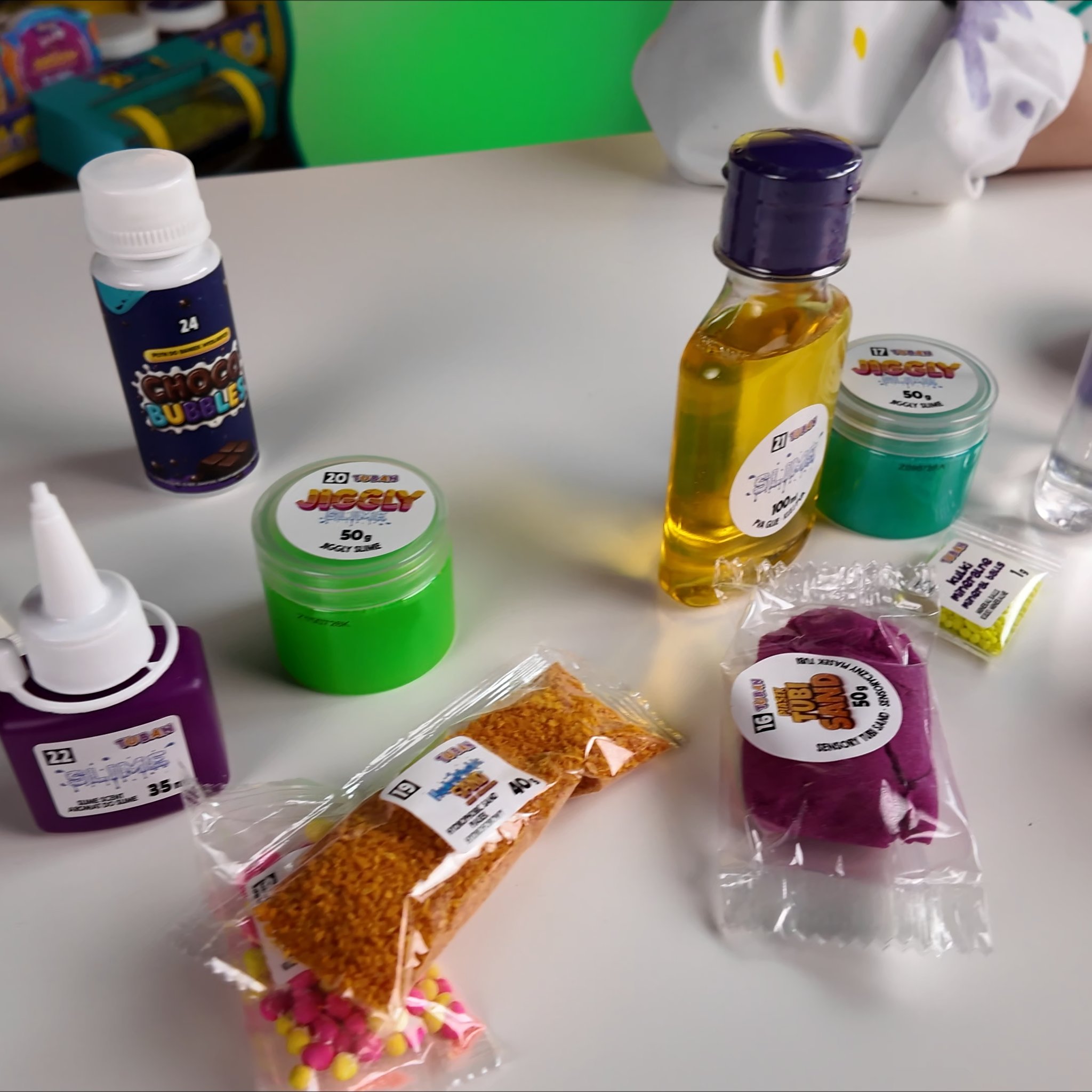 Inhalt des Slime-Adventskalenders mit Flaschen, Slime-Döschen, Sand und Deko-Material