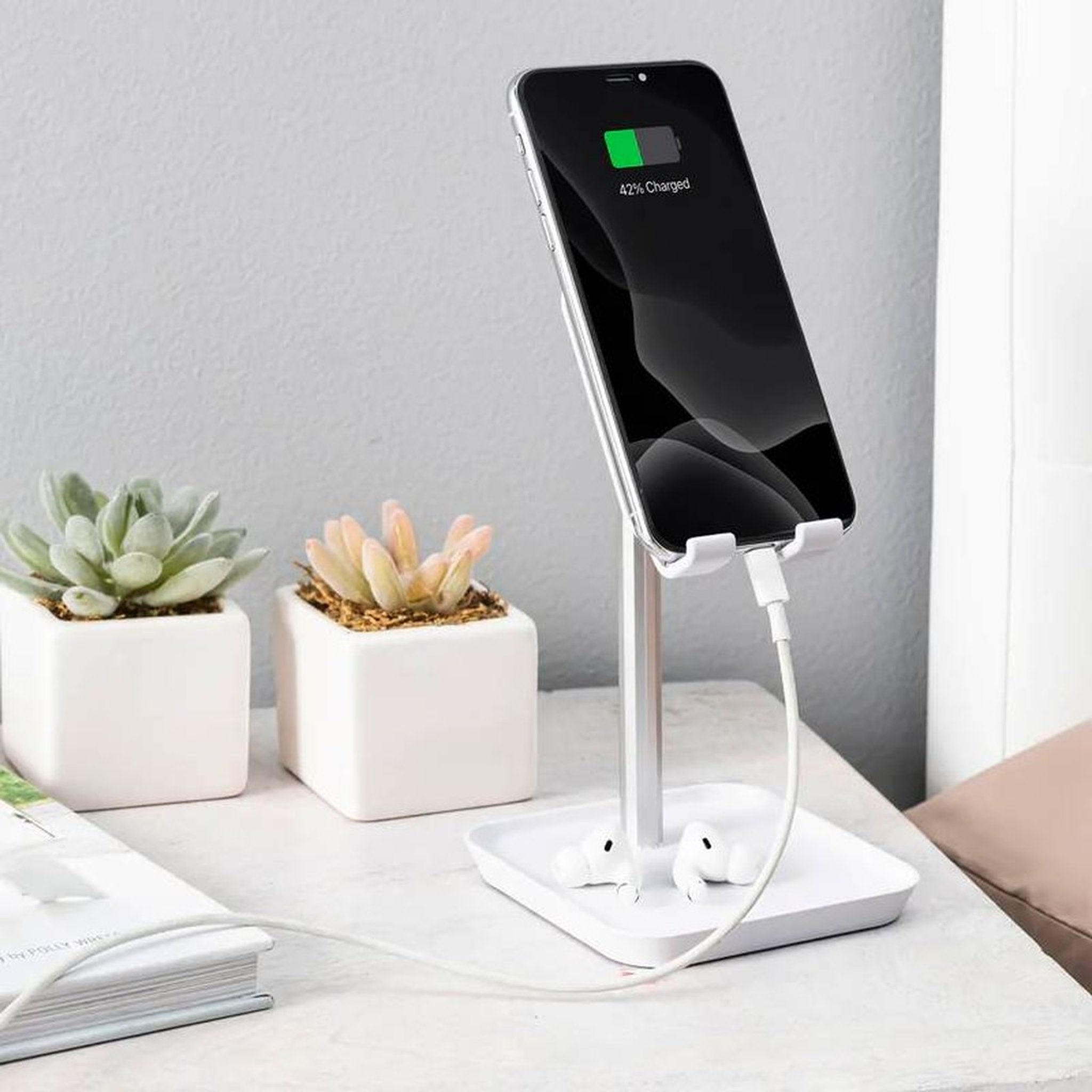 Smartphone lädt im Halter, Kabel durch die Basis geführt