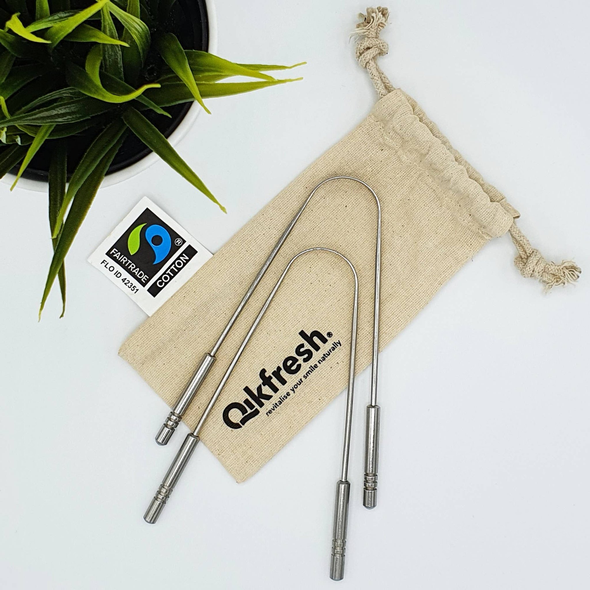 I due puliscilingua a U appoggiati sul sacchetto Qikfresh in cotone Fairtrade