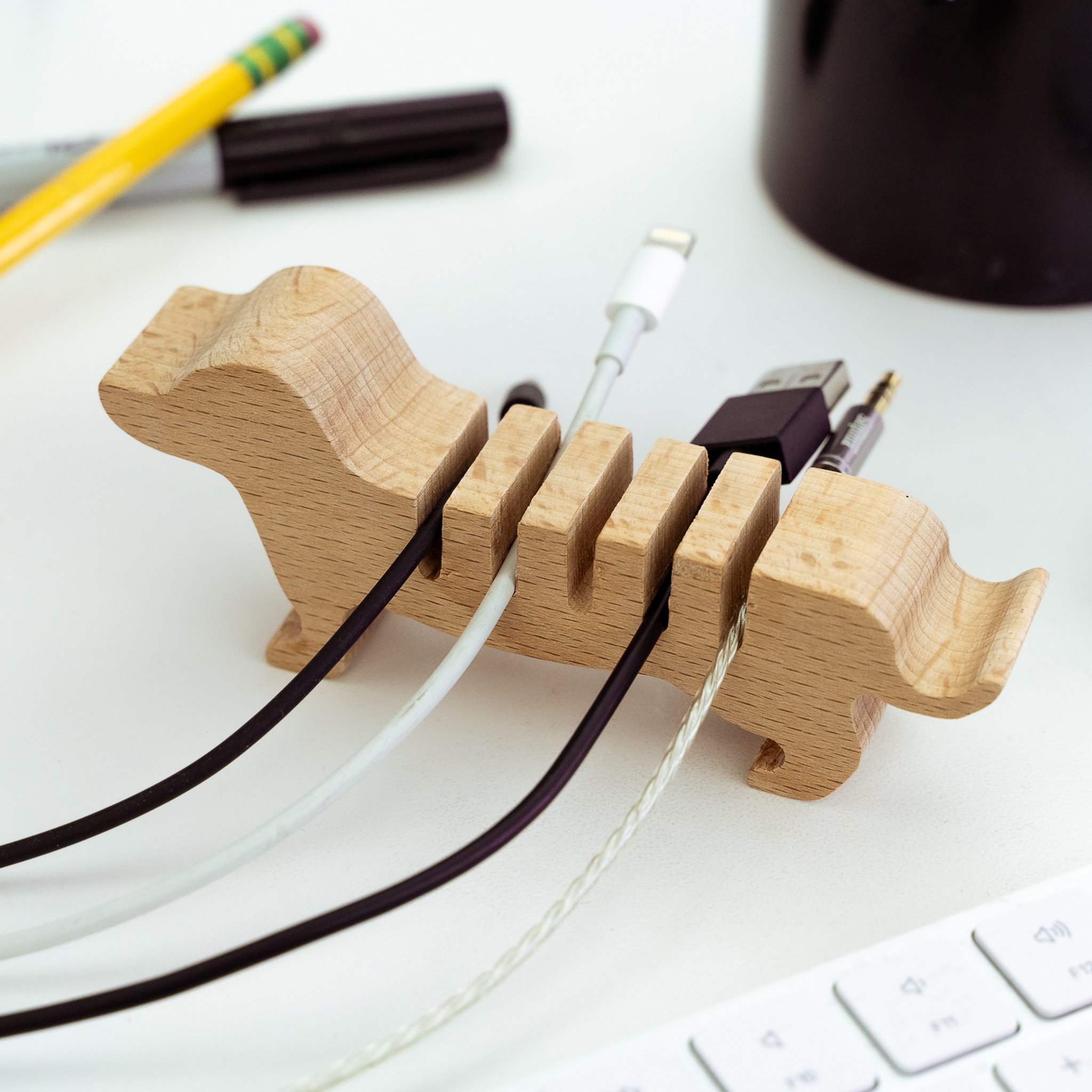 Kabelhalter-Hund aus Holz hält Kabel auf dem Schreibtisch