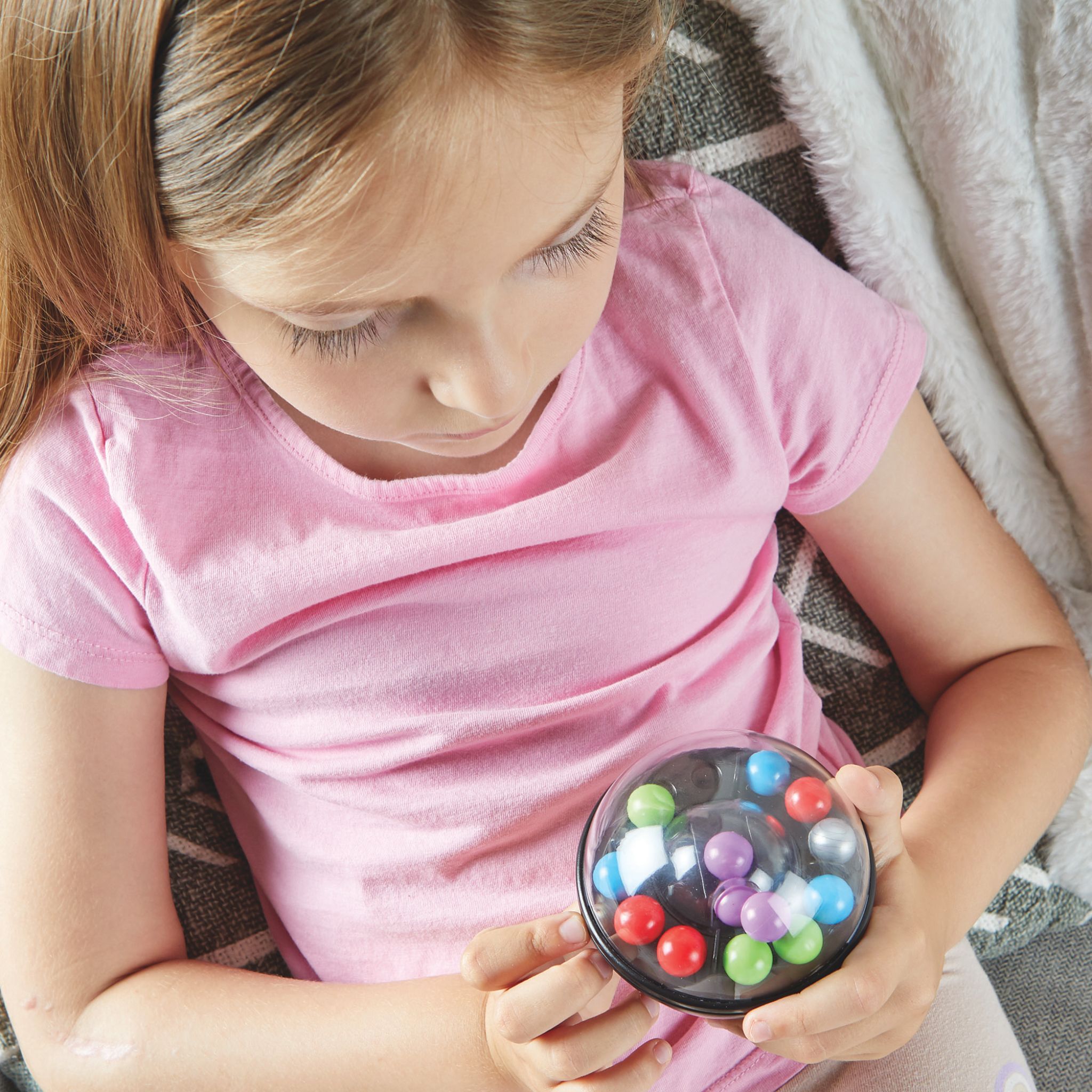 Mädchen dreht konzentriert den Scramboozle Puzzle-Ball