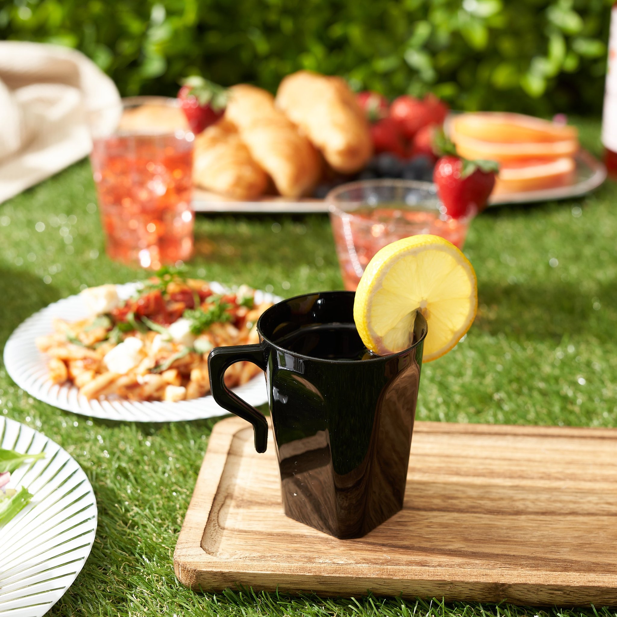 Schwarzer Kaffeebecher mit Lichterkette Outdoor-Stimmung