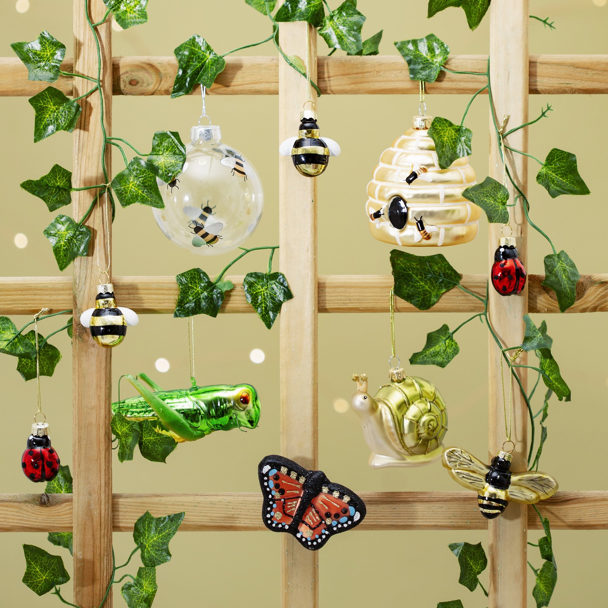 Bee decoration with other garden-themed ornaments on an ivy-covered trellis