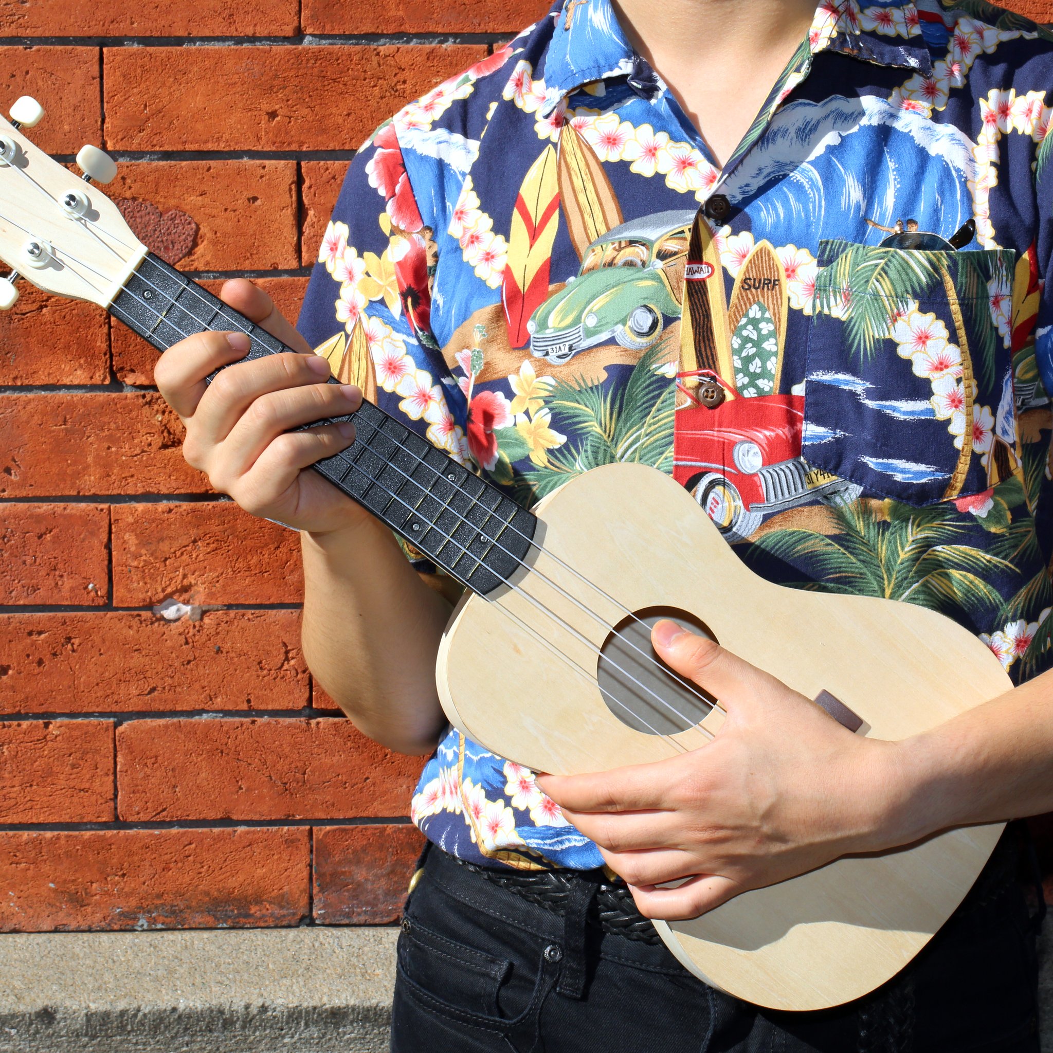 Mann im Hawaiihemd spielt die selbst gebaute Ukulele