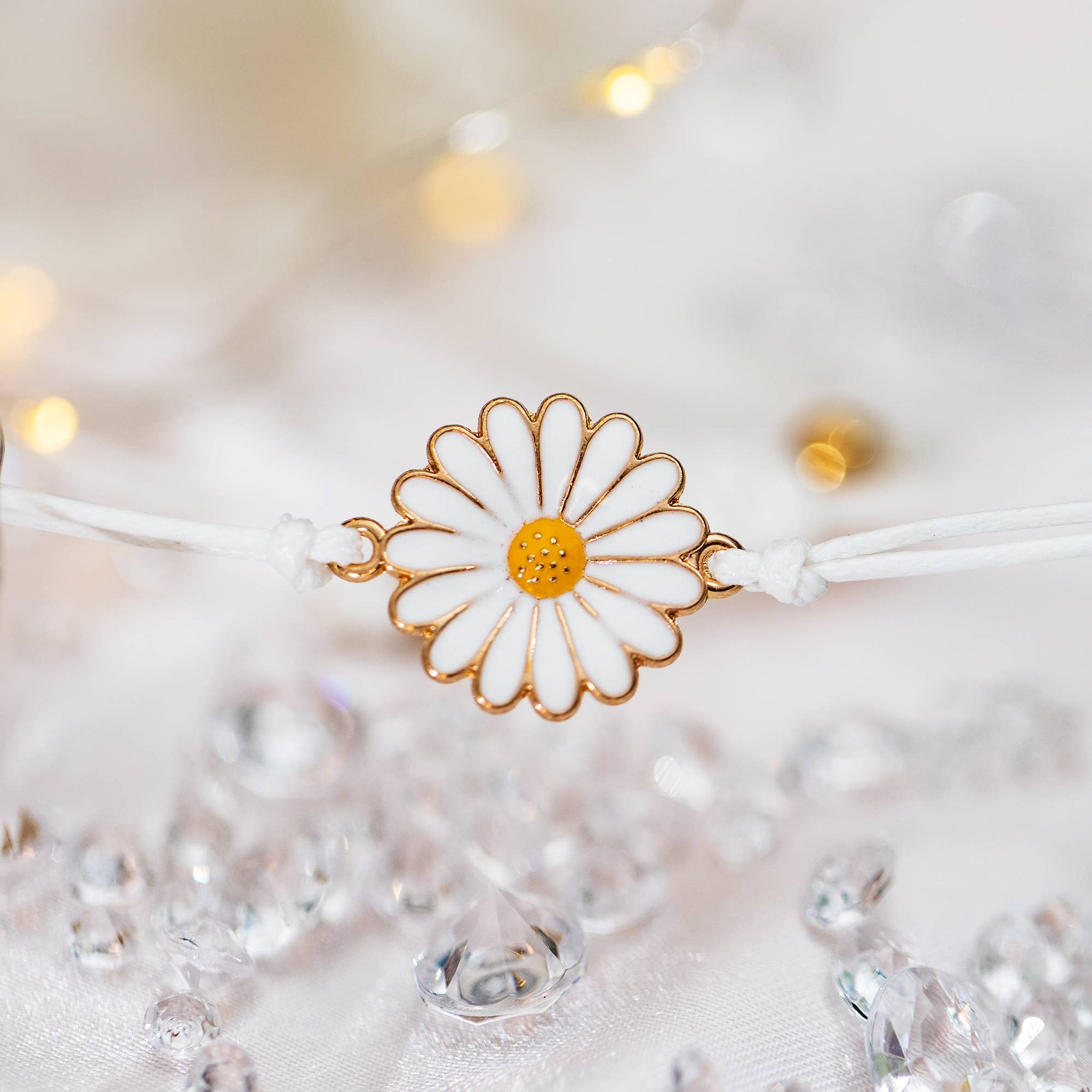 Gänseblümchen-Anhänger des Danke-Armbands zwischen glitzernden Glassteinen