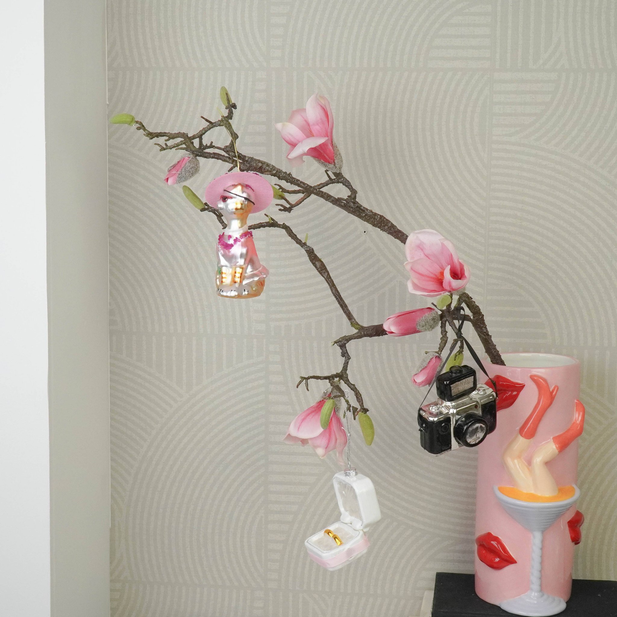 Diva-Katze Anhänger hängt mit weiteren Anhängern an einem Magnolienzweig