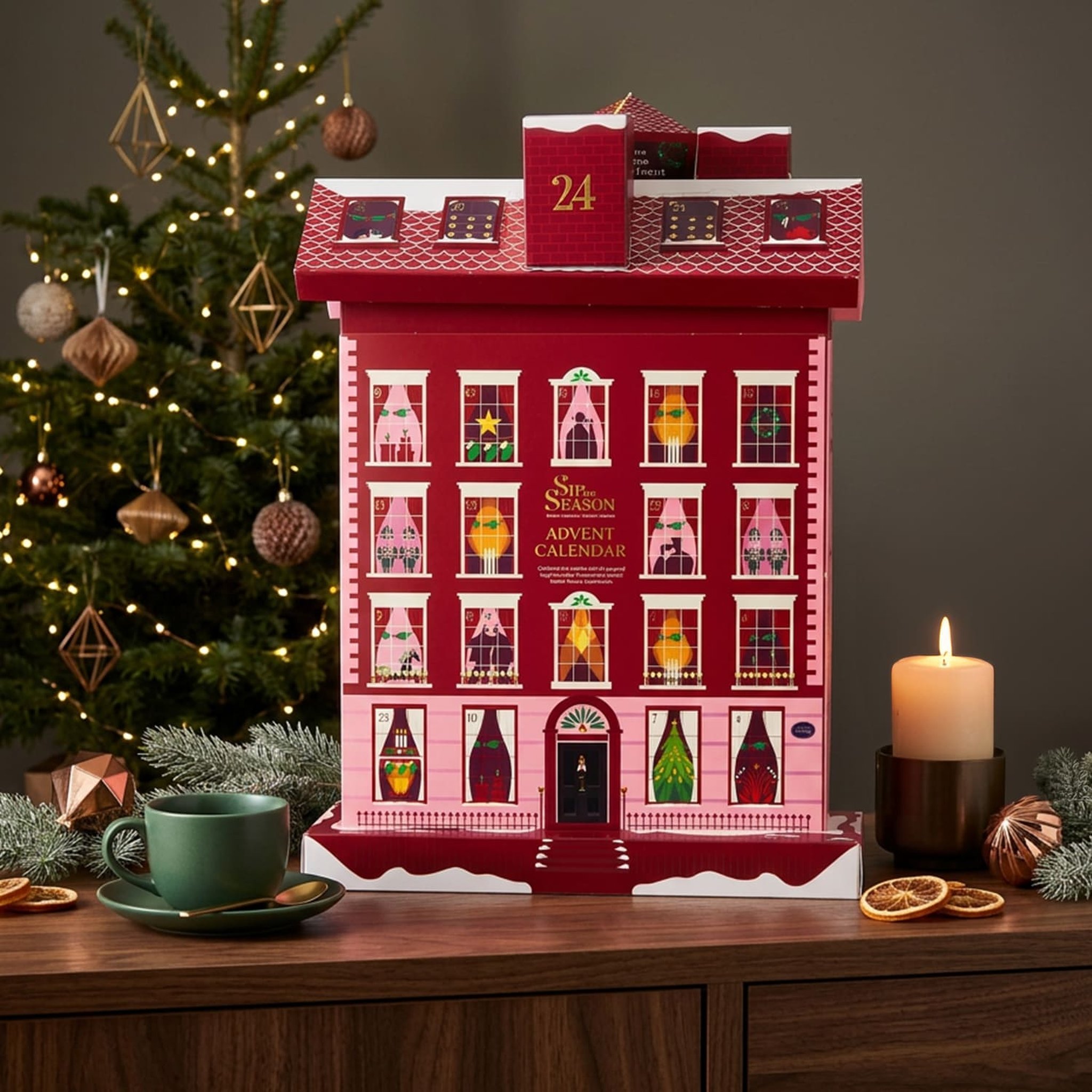 Calendrier de l'Avent au thé sur une commode près du sapin, avec bougie et tasse de thé