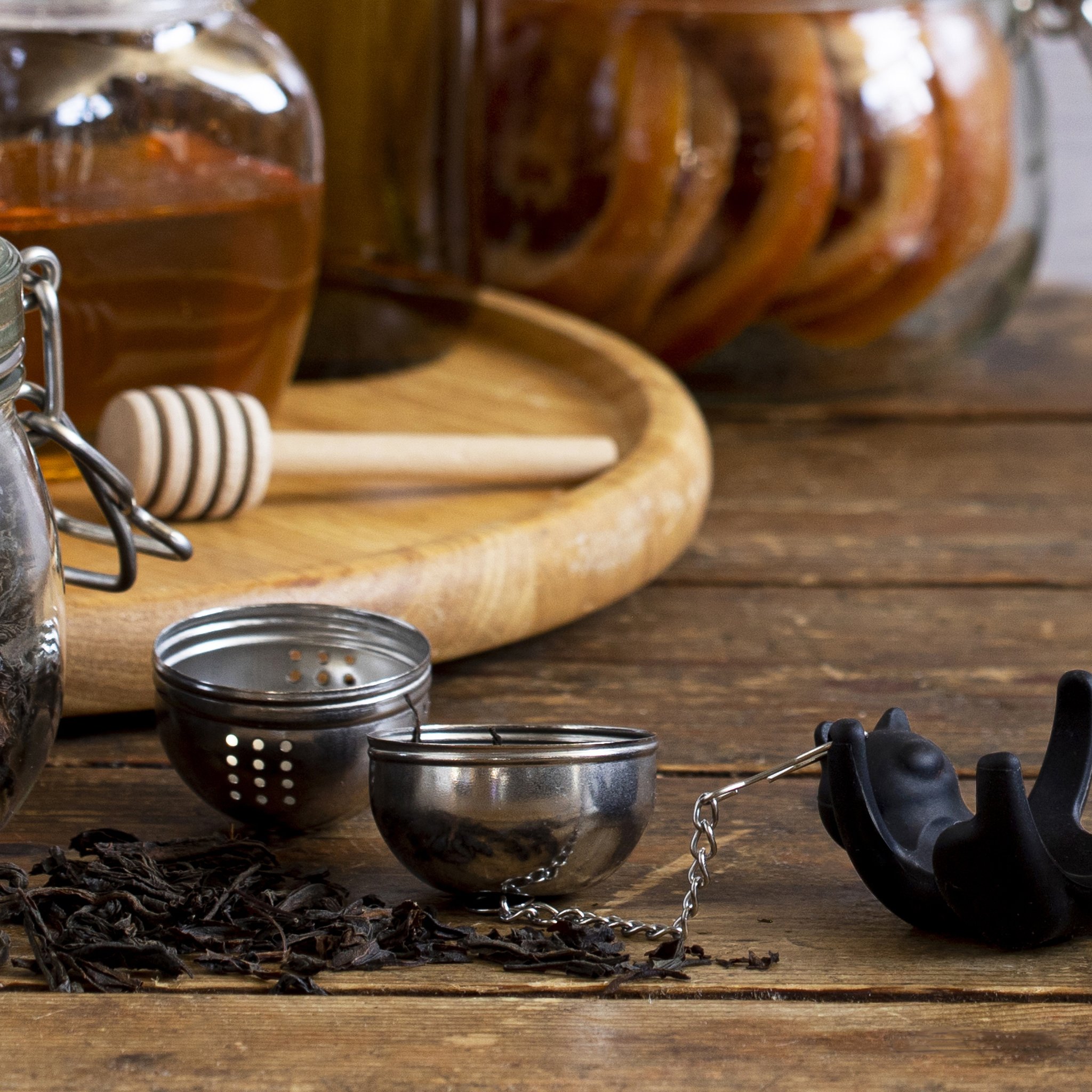 Cattea tea infuser disassembled with loose black tea and honey jars on wood