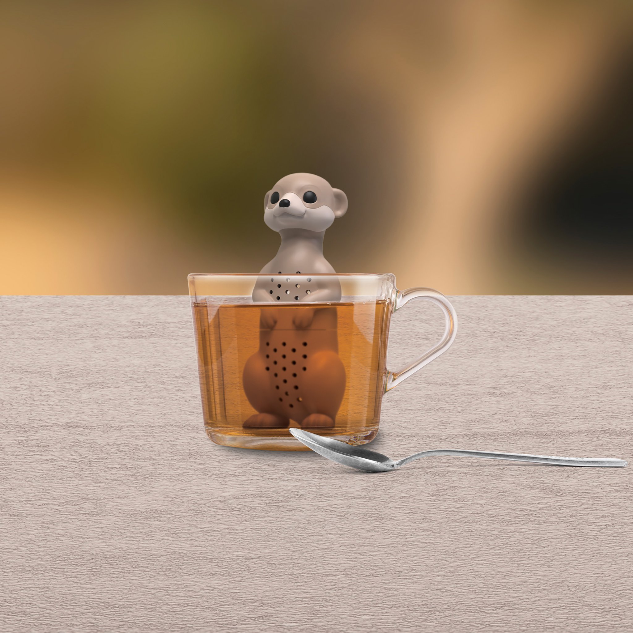 Erdmännchen Teesieb an einer Teetasse auf Holz