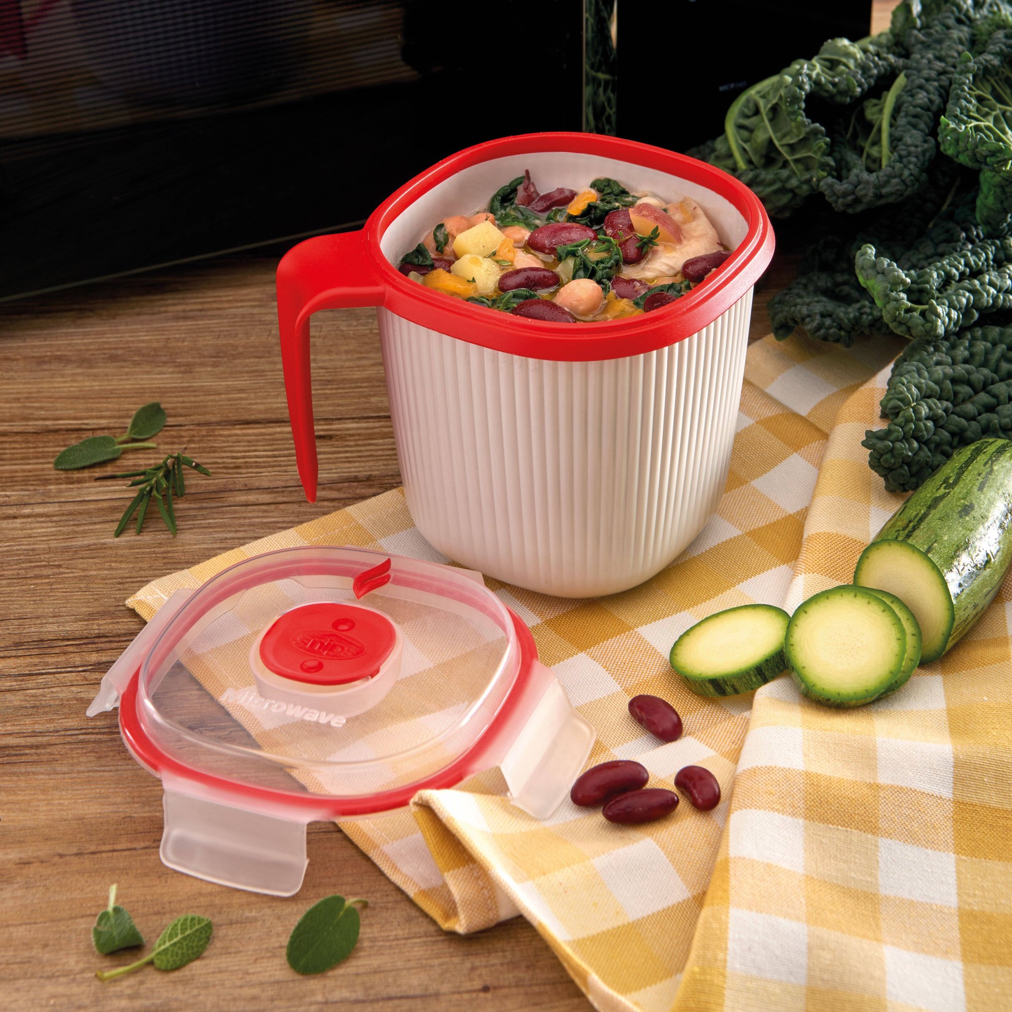 Mikrowellen-Tasse mit Gemüsesuppe vor der Mikrowelle