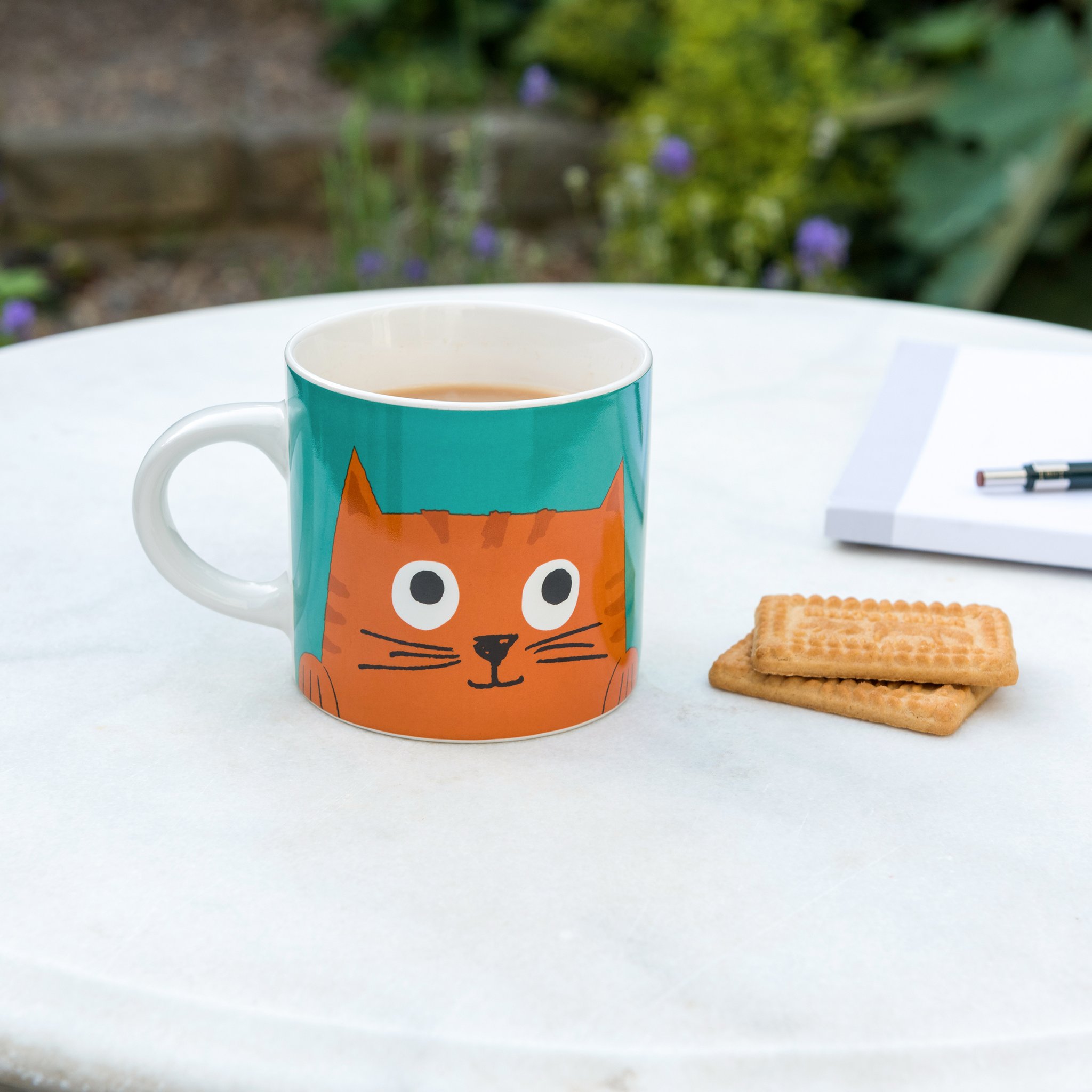 Tasse Chester auf dem Marmortisch neben Notizbuch und Keksen