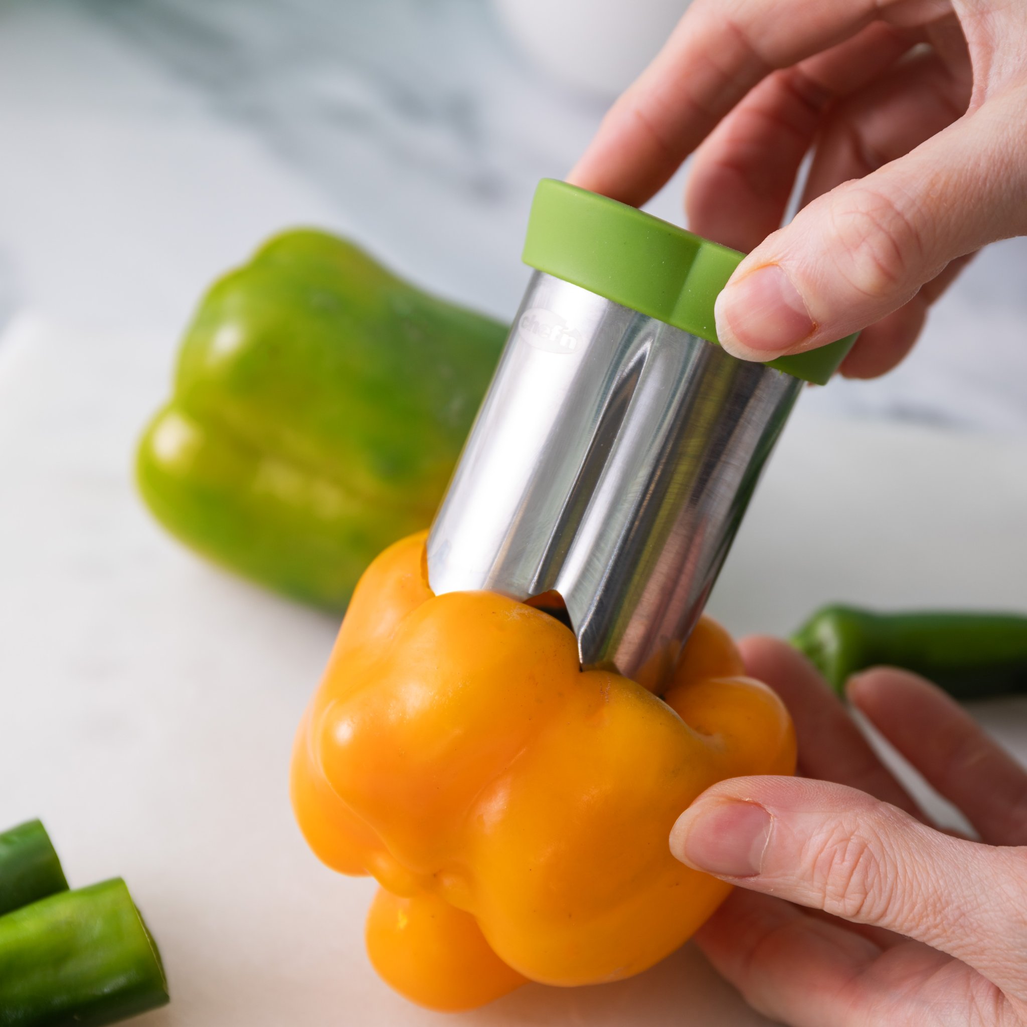 Paprika-Entkerner wird in eine gelbe Paprika auf der Marmorplatte gedreht