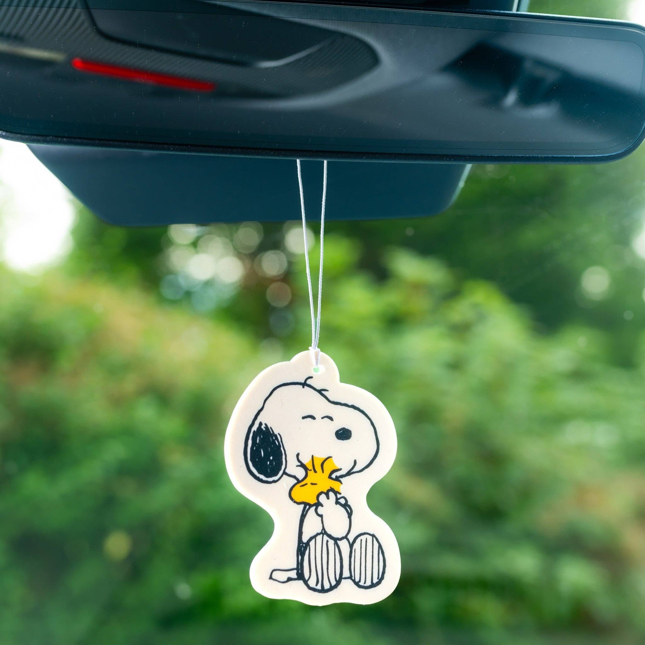 Snoopy-Lufterfrischer Hugs hängt am Rückspiegel im Auto
