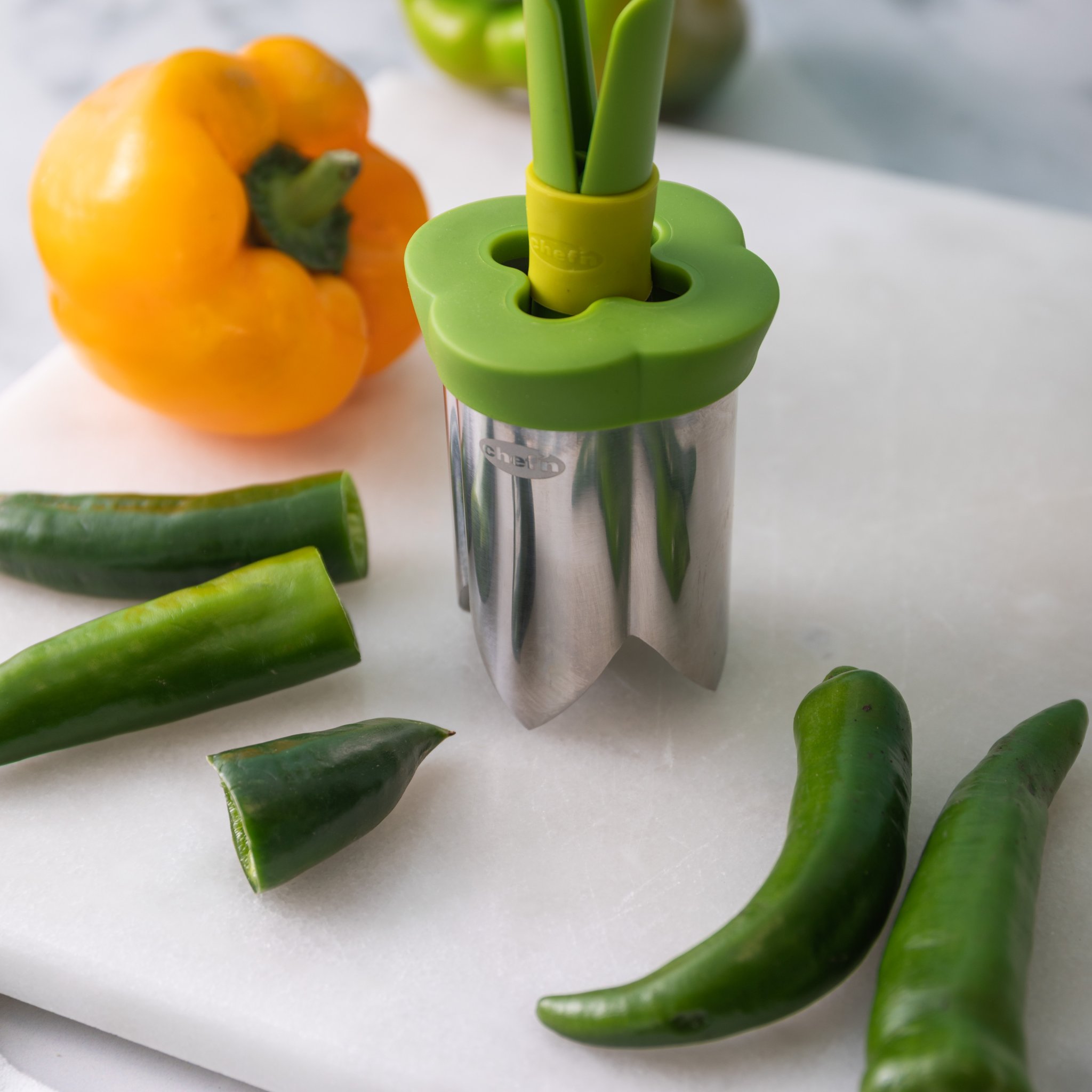 Entkerner-Set in der Küche zwischen gelber Paprika und frischen Jalapeños