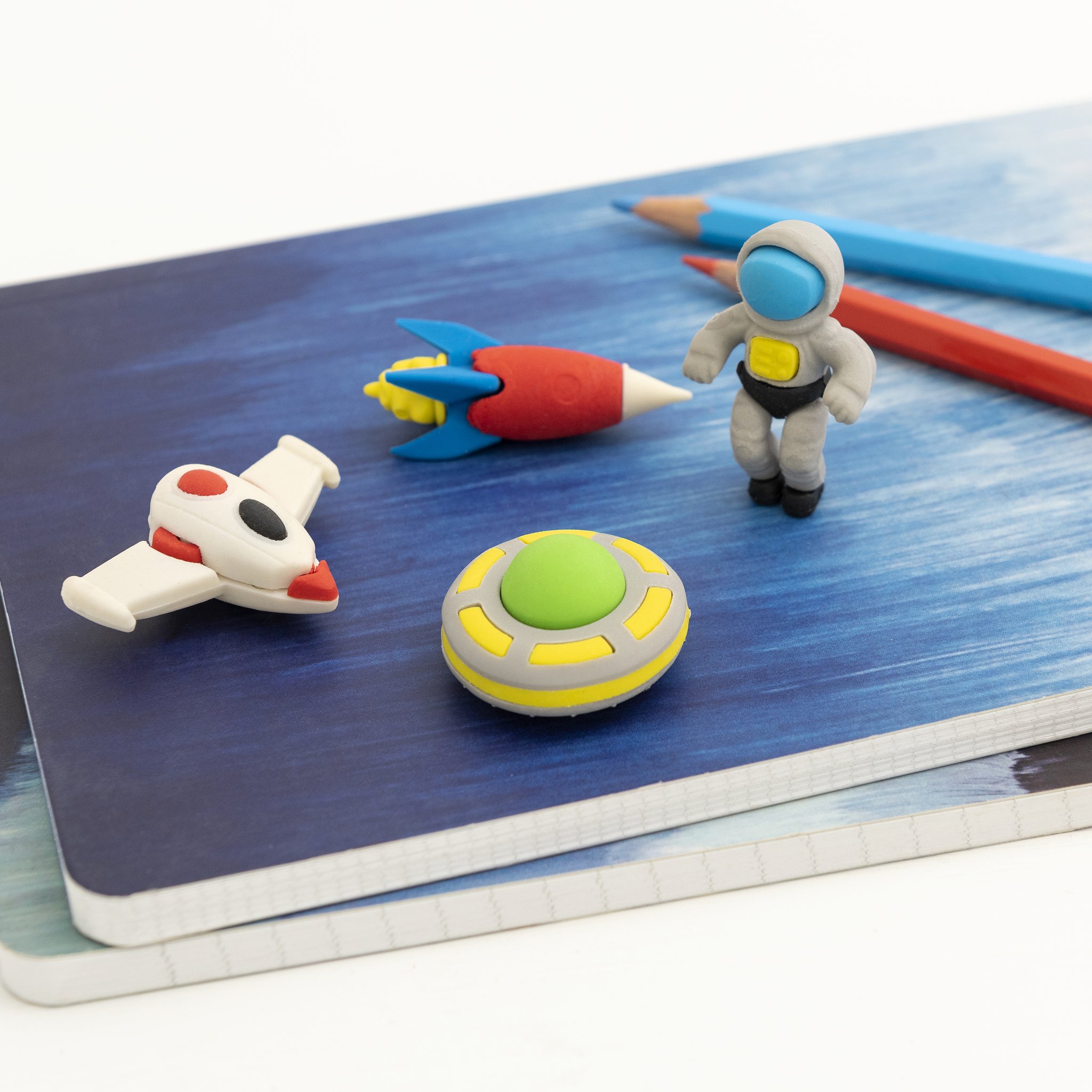Space Age eraser set: rocket, astronaut, spaceship and UFO on a notebook